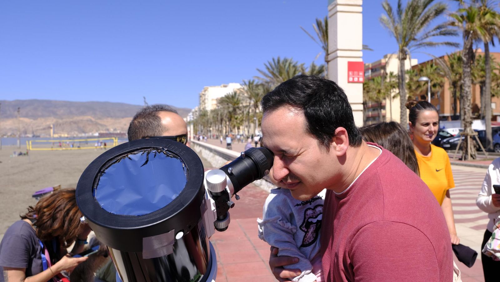 Almería observa el eclipse solar desde el Paseo Marítimo, en imágenes