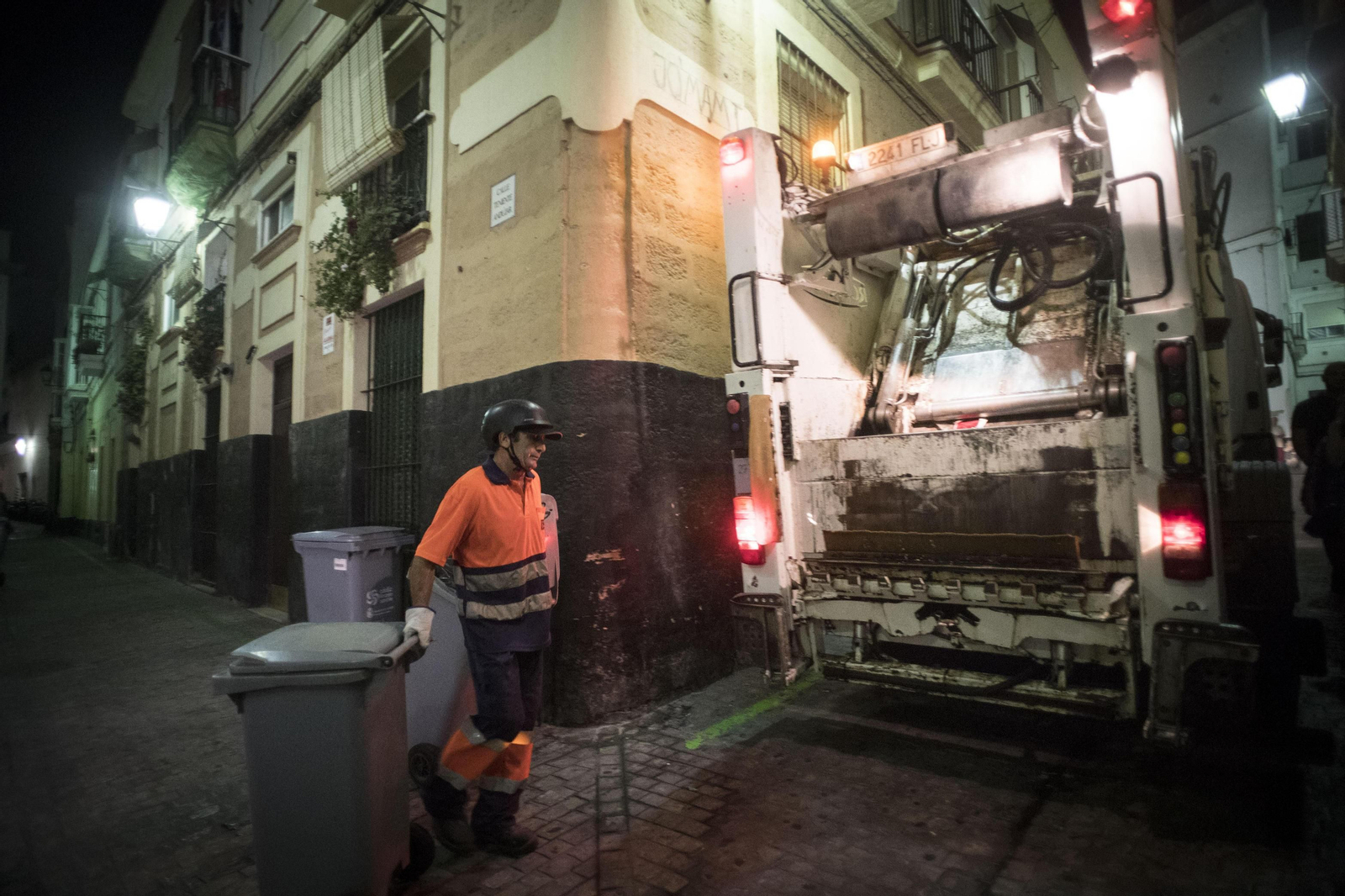 Un operario de la limpieza carga en el camión los contenedores de basura en el barrio de Santa María.