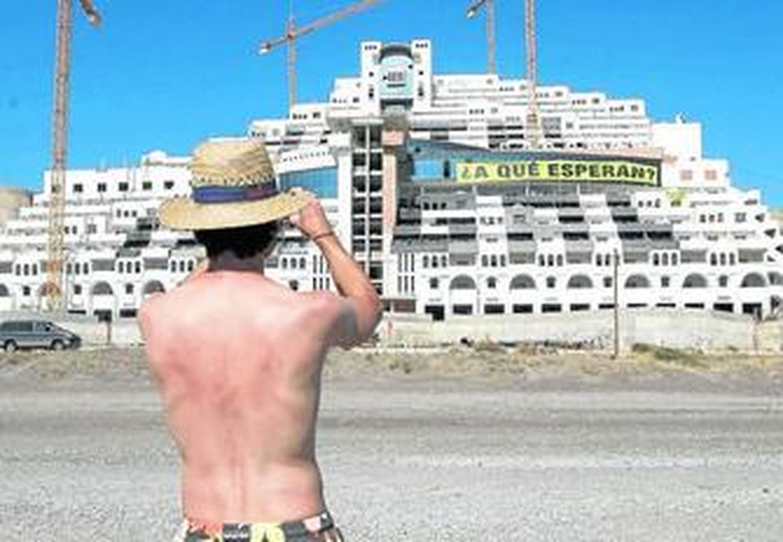 Un hombre fotografía la edificación del hotel en el Algarrobico.