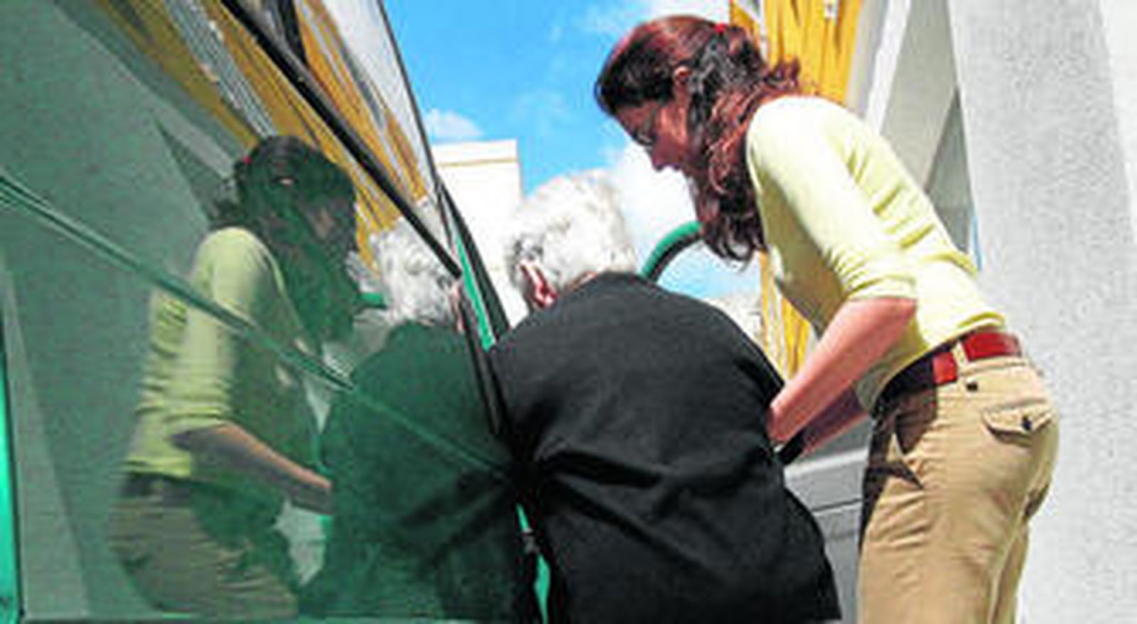 Una anciana accede a una furgoneta para acudir a un centro asistencial.