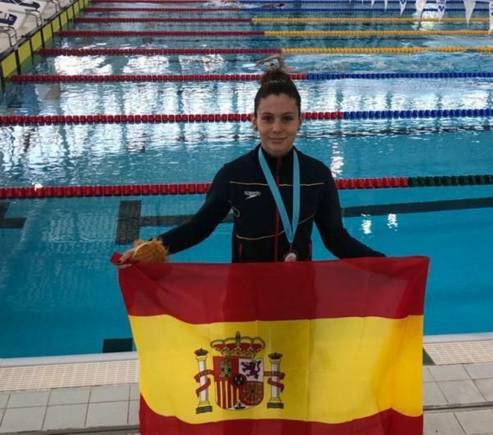 Mely Ruiz con la bandera de España y su medalla al cuello.