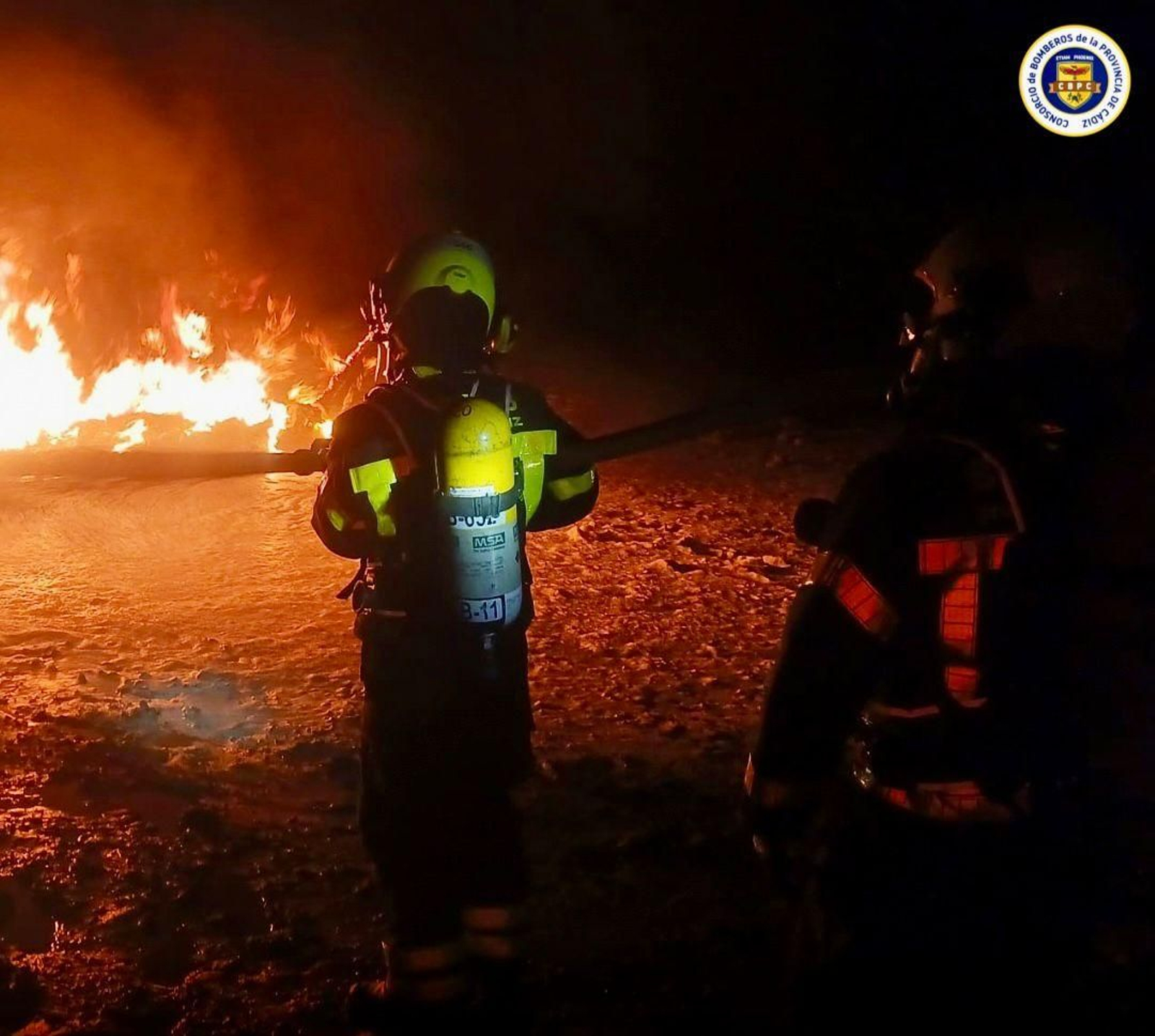 Bomberos sofocando el incendio en los Toruños, en Puerto Real
