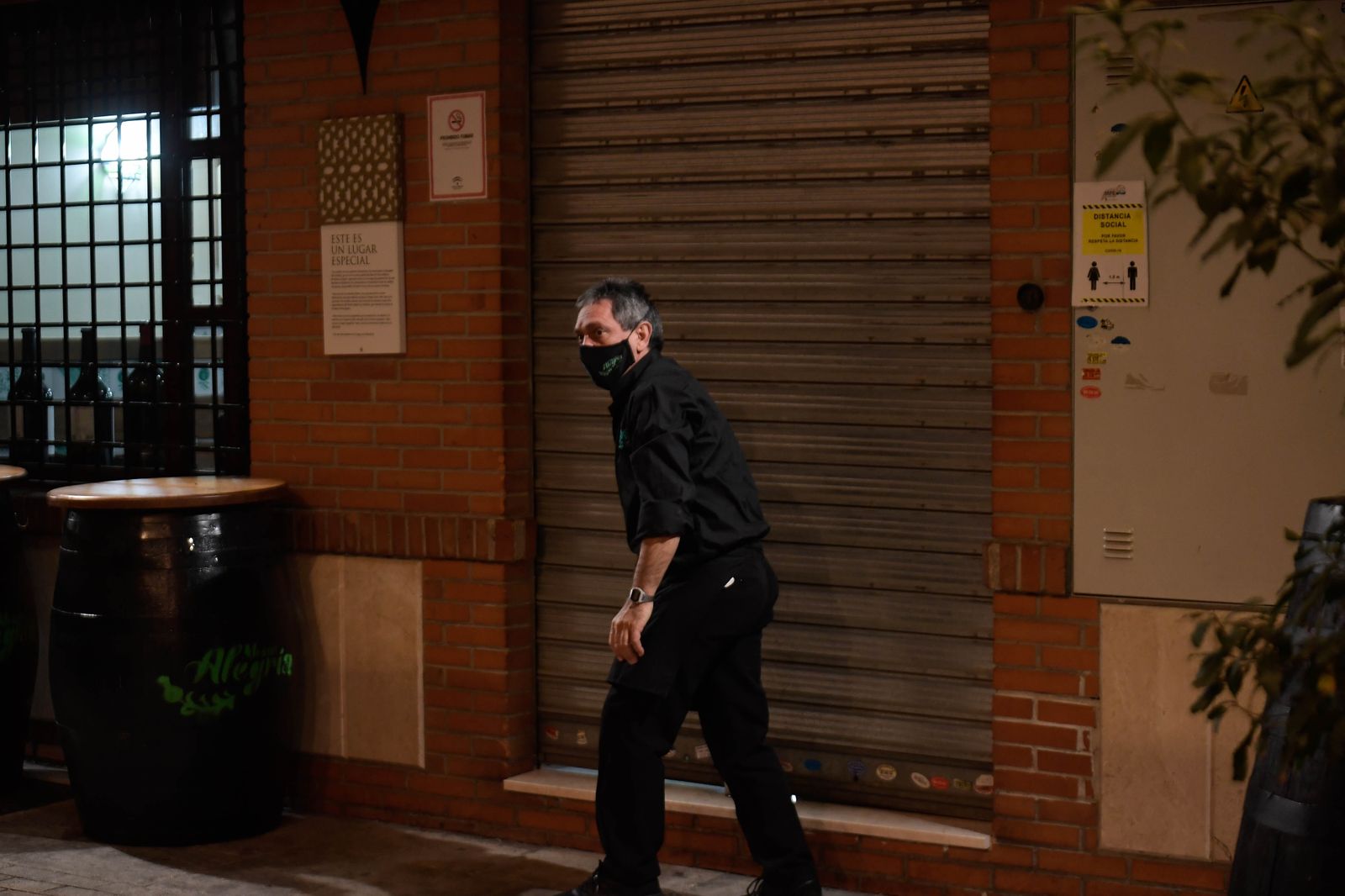 Un camarero echa el cierre en un bar en Granada.