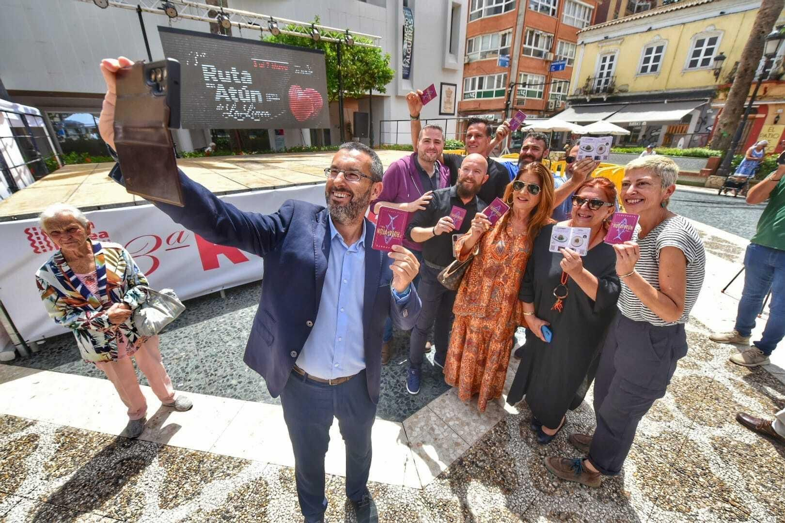 El alcalde, Juan Franco, se toma un selfi con hosteleros que muestran la guía de las tapas.