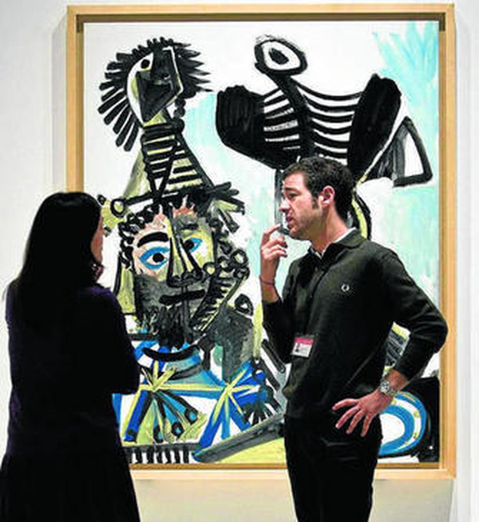 Unos operarios observan el lienzo 'Hombre, mujer y niño'