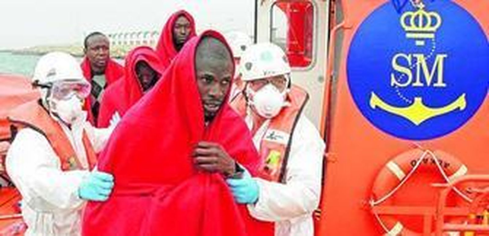 Miembros de Salvamento desembarcan a un grupo de inmigrantes en Tarifa, después de ser rescatados en el Estrecho.
