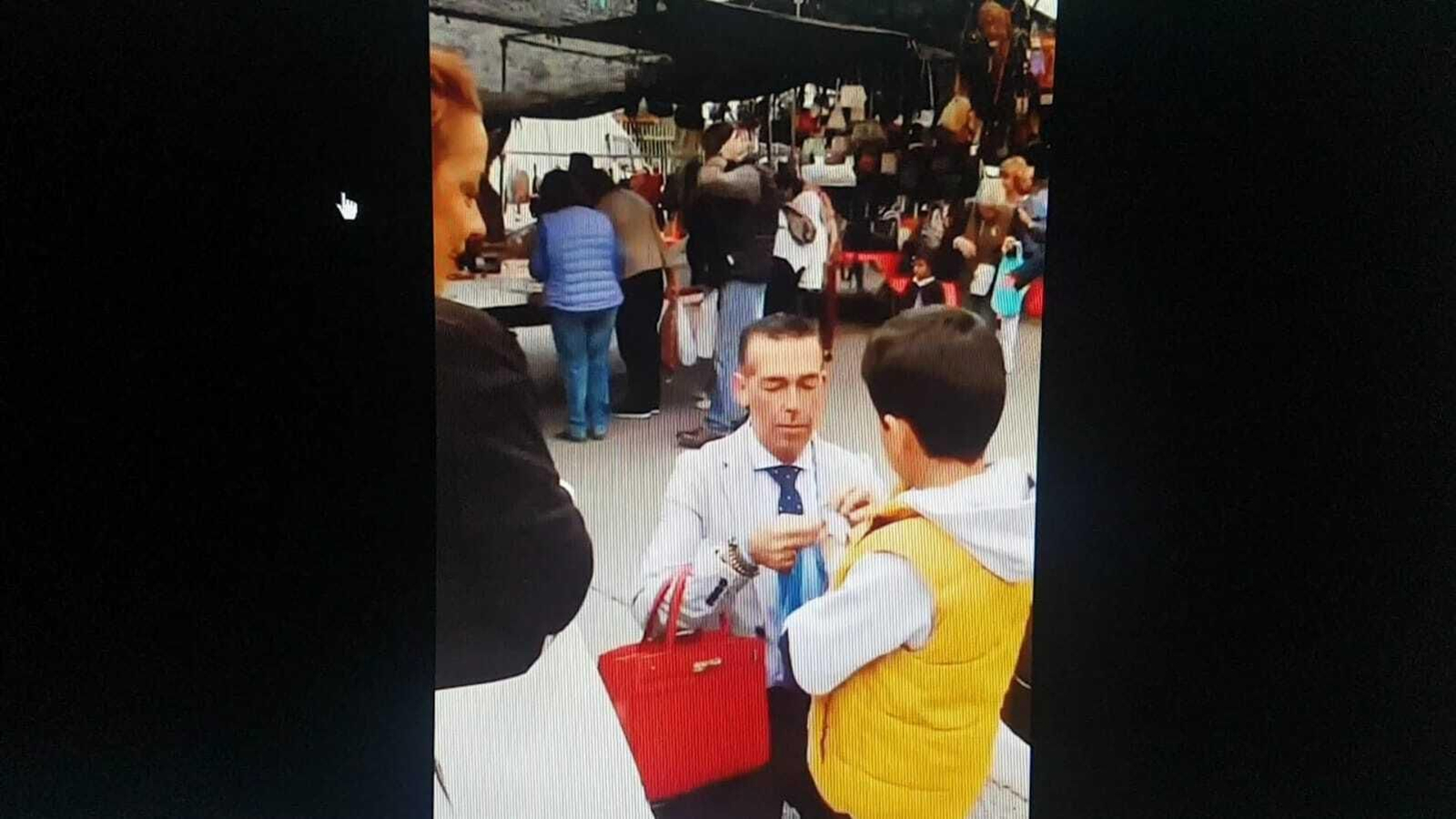 El concejal, en una imagen de sus redes sociales obsequiando con  una pulsera a un menor en el Mercadillo de los Martes.