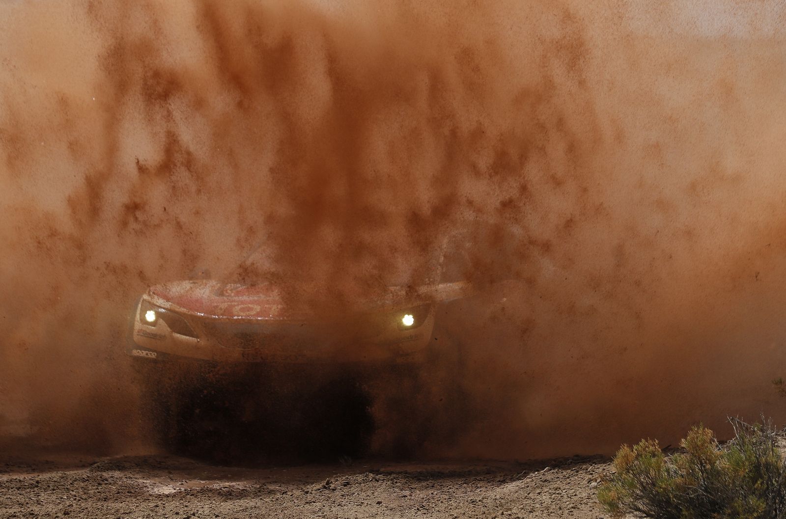 Sebastien Loeb y su copiloto, Daniel Elena, superan una zona de barro durante la etapa de ayer en el Dakar.