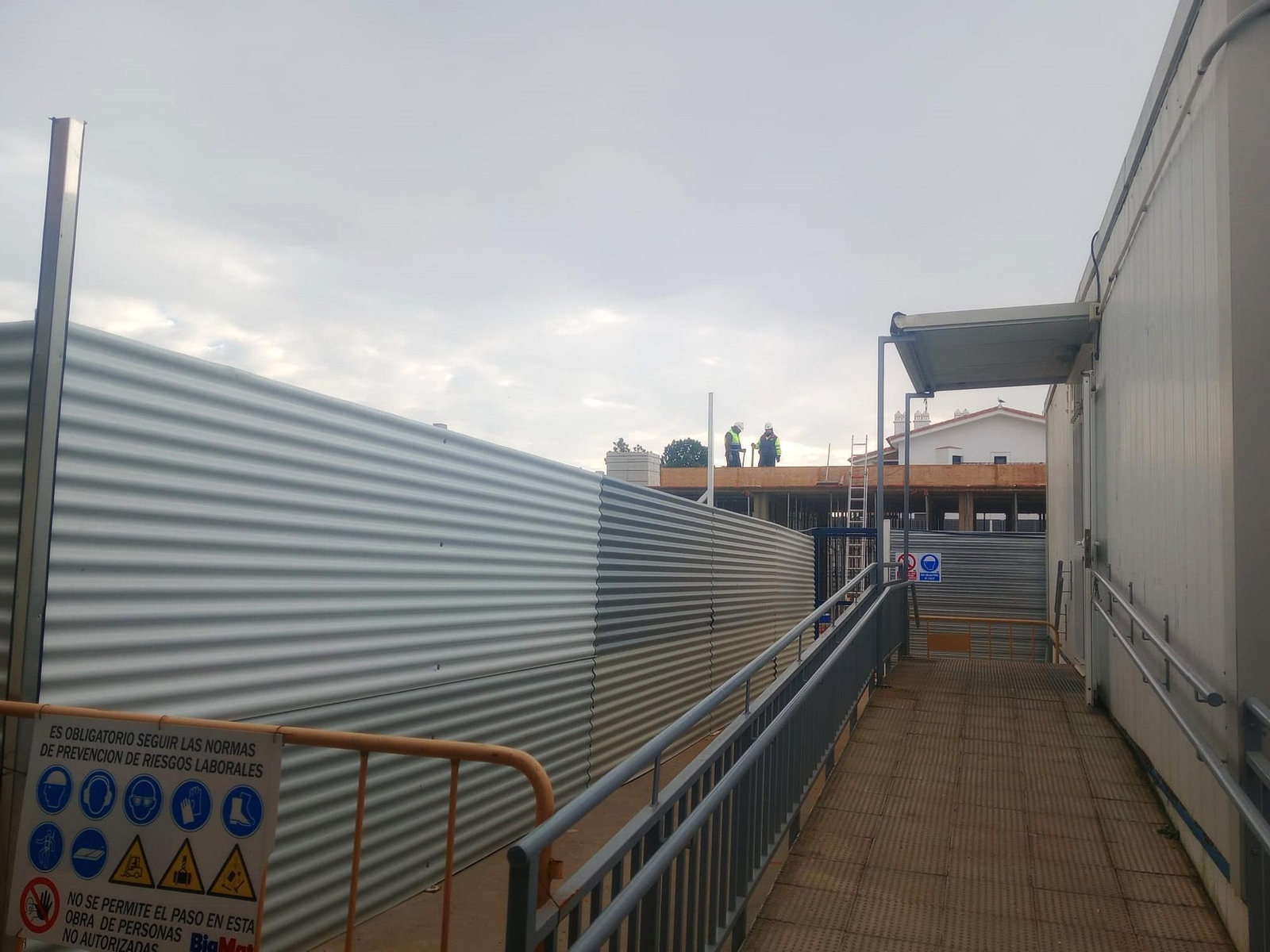 Apenas un par de metros separan las aulas de la obra