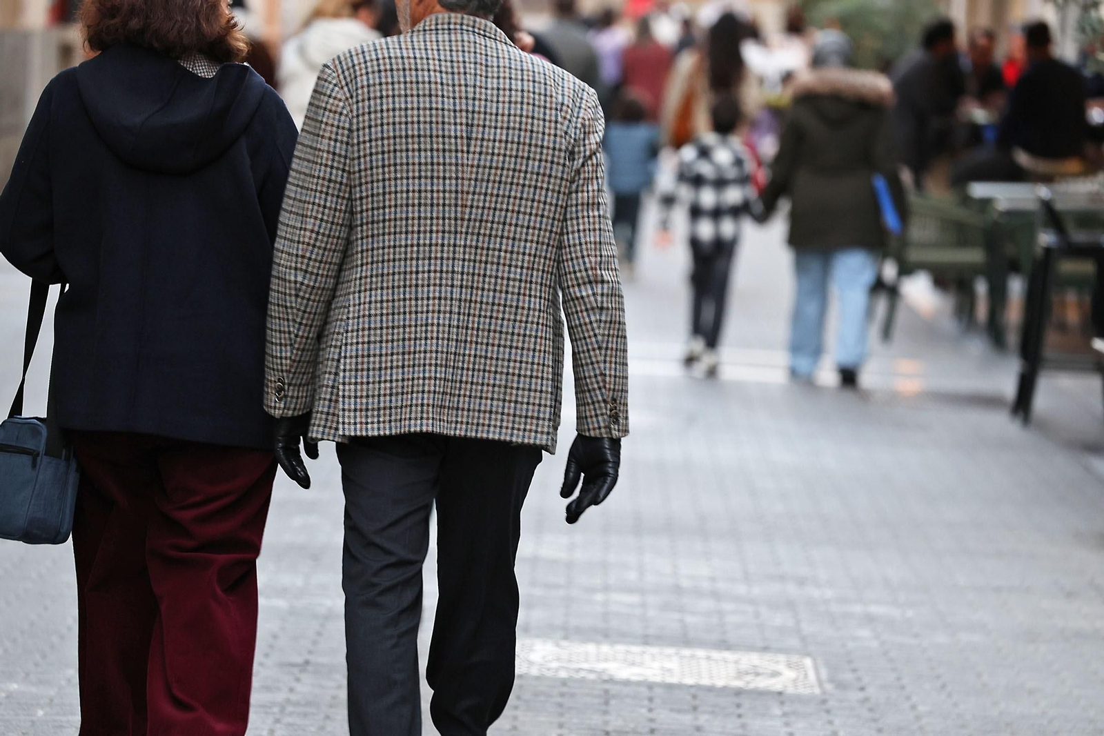 Personas con abrigos y guantes de protegen del frío en Huelva.