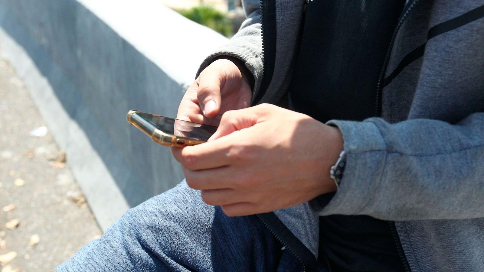 Un hombre mira su teléfono móvil.