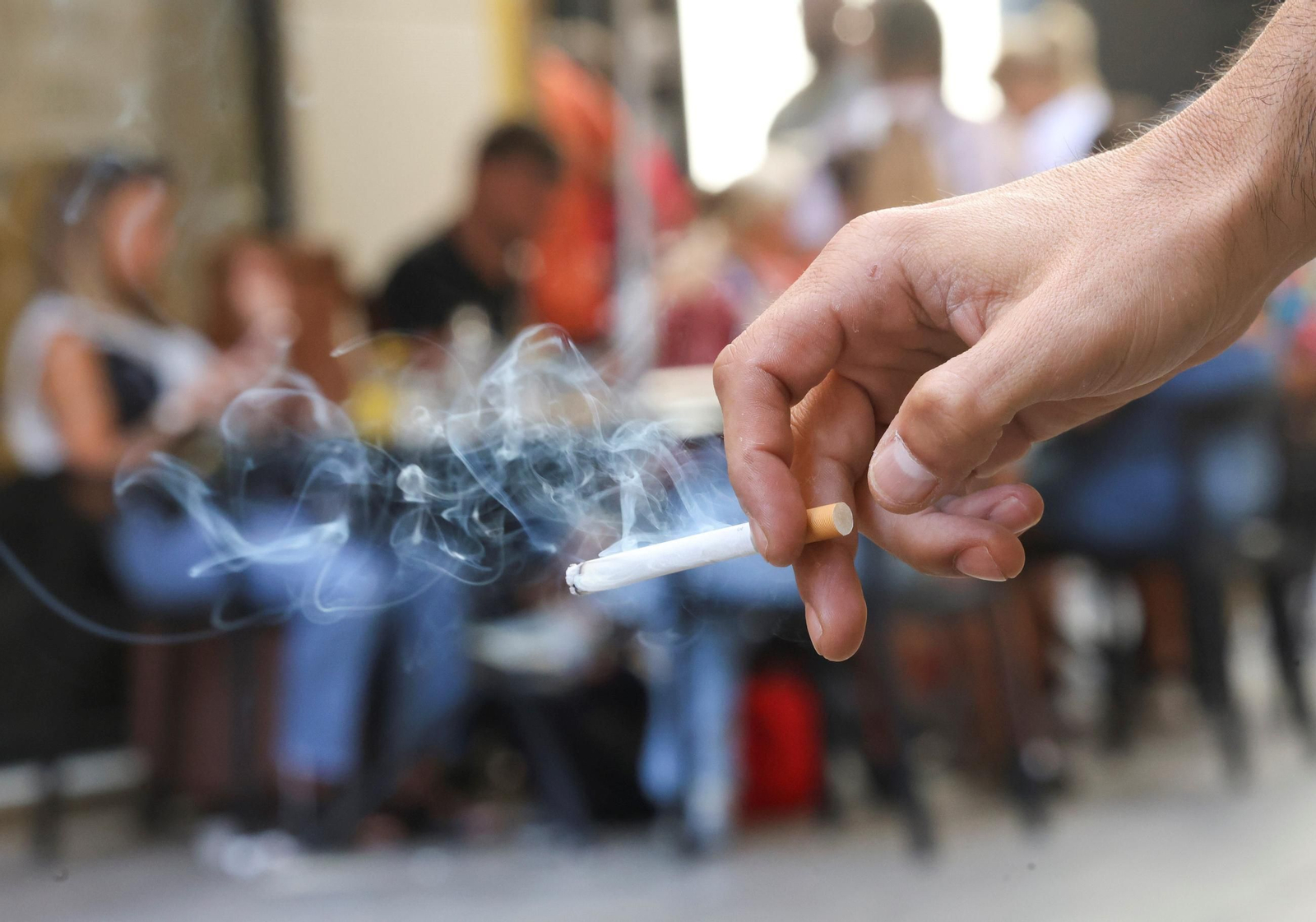 Un hombre sostiendo un cigarrillo, este miércoles, en una zona de restaurantes del Centro.