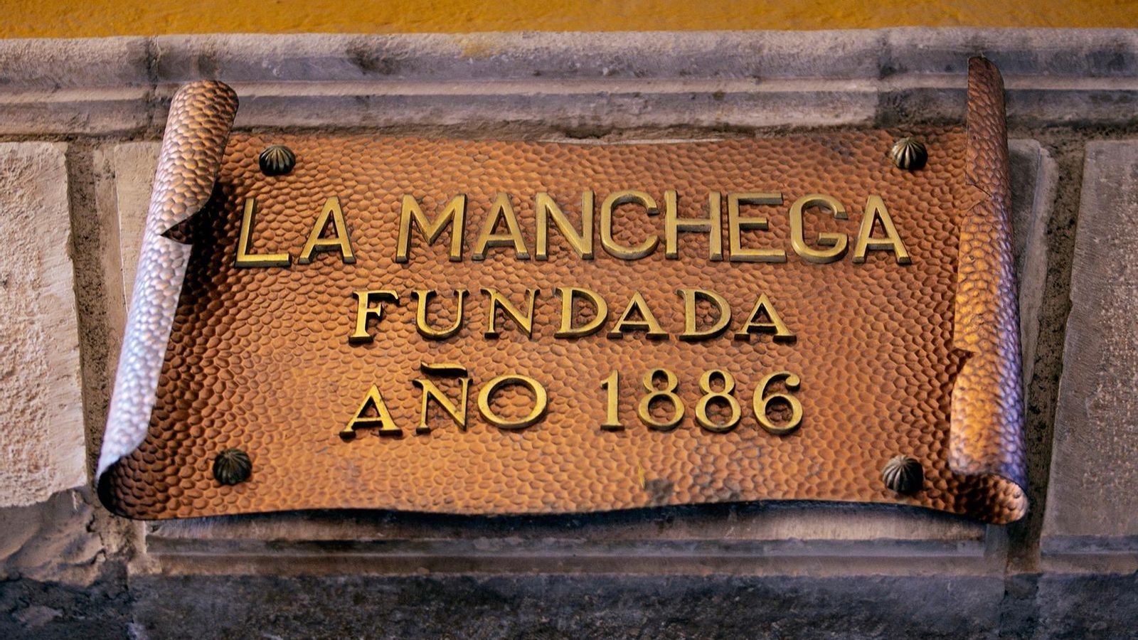 Cartel fundacional que cuelga bajo una de las puertas de acceso.