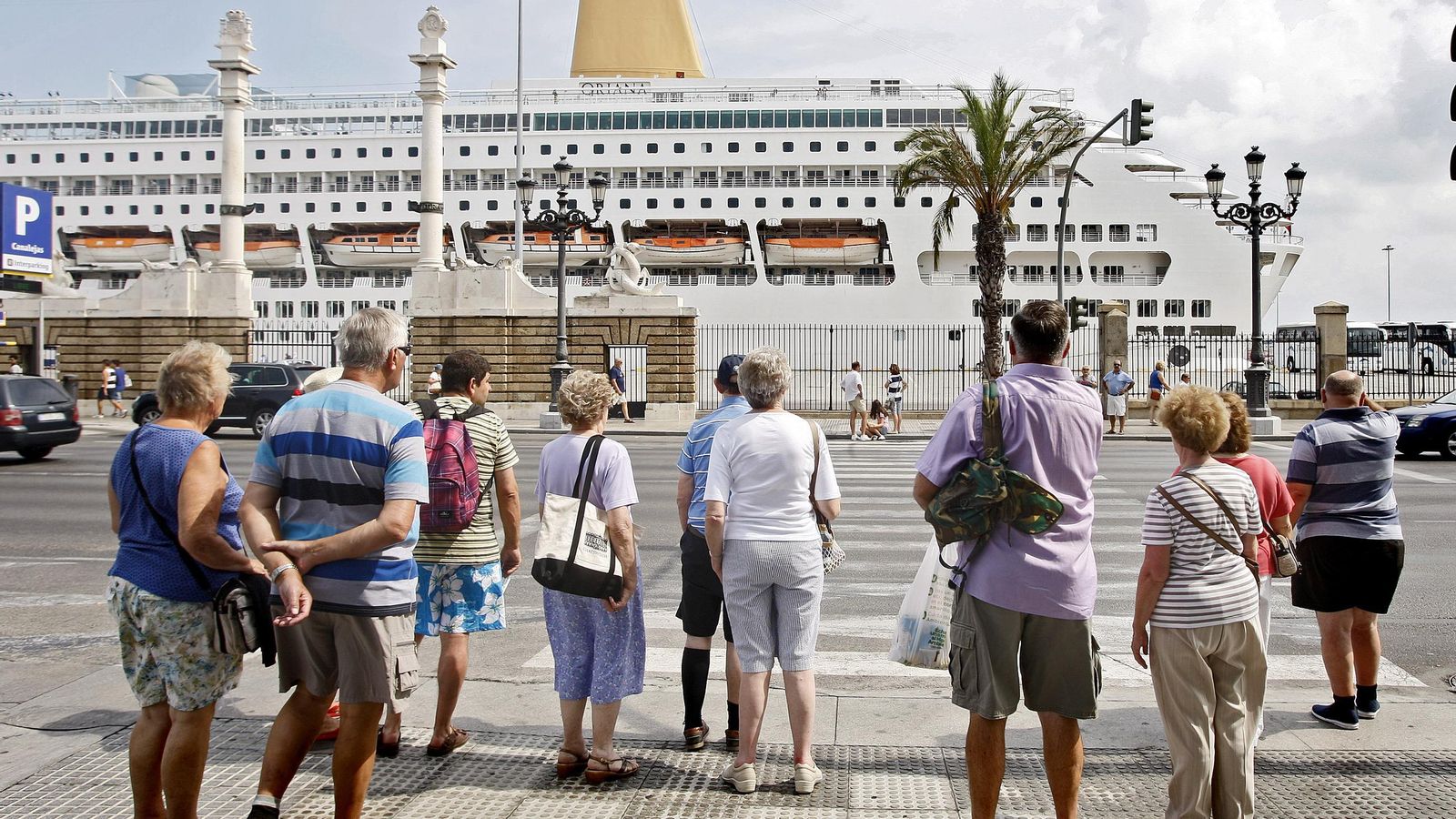 Varios turistas, en la plaza de San Juan de Dios de Cádiz, a muy pocos metros de un crucero atracado en el Muelle Ciudad del puerto de Cádiz