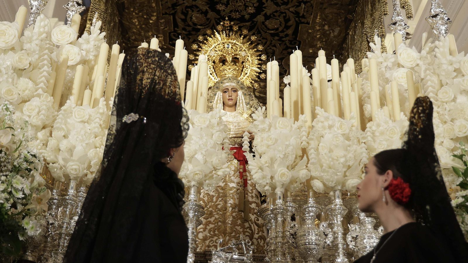 Dos jóvenes vestidas de mantilla contemplan la imagen de la Esperanza de Triana. Dos jóvenes vestidas de mantilla contemplan la imagen de la Esperanza de Triana.