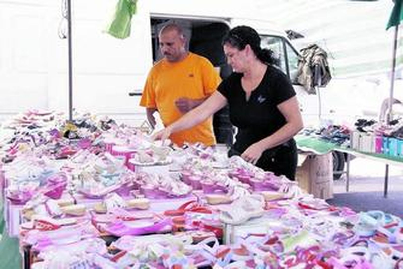 Un matrimonio ordena los productos de su puesto de venta.