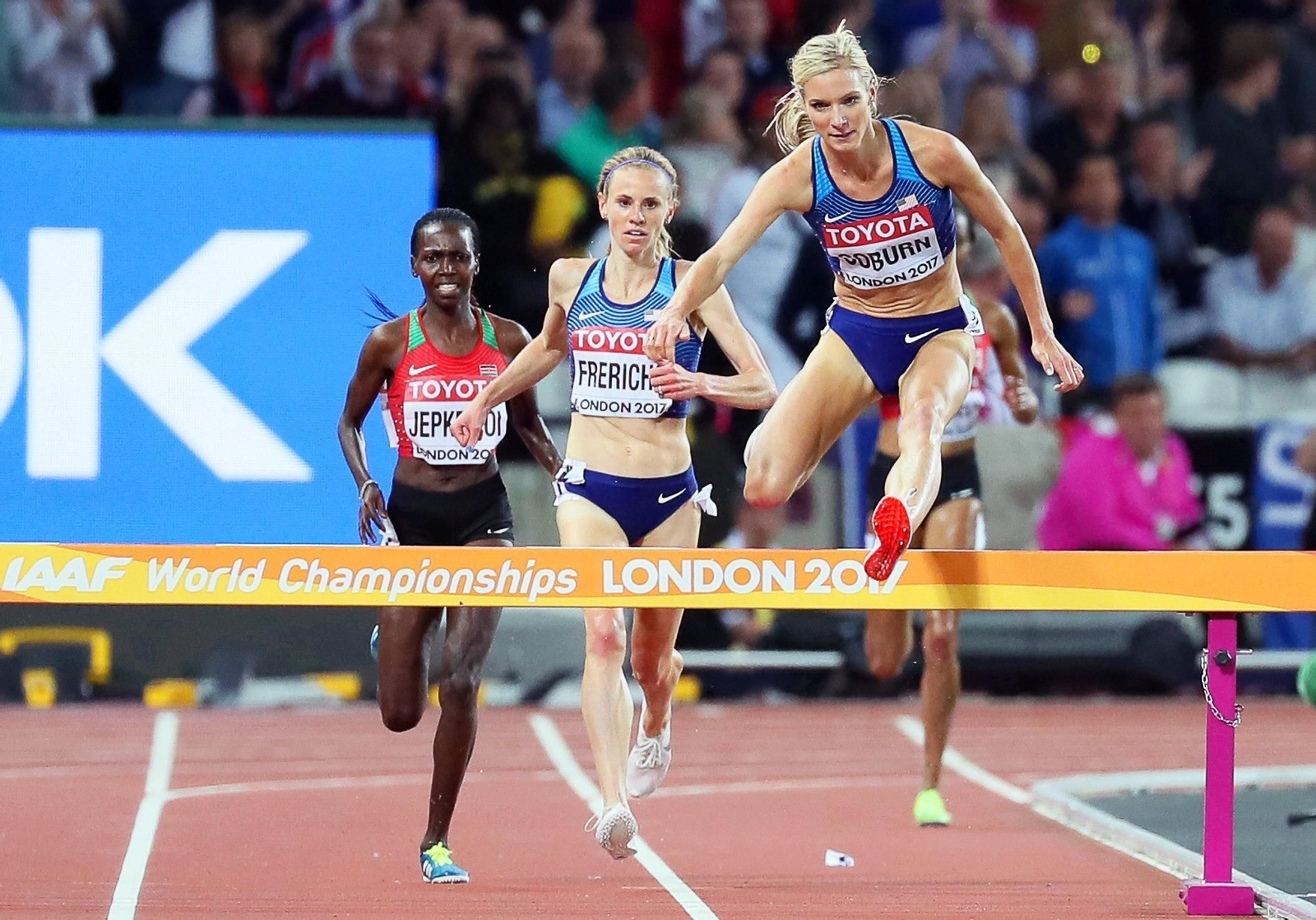 Emma Coburn, campeona del mundo de 3.000 obstáculos, salva una valla de los últimos metros seguida de su compatriota Courtney Frerichs.