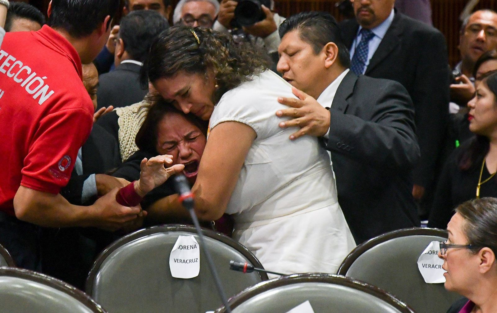 Varios legisladores consuelan a la diputada mexicana Carmen Medel Palma, tras saber que su hija había sido asesinada.