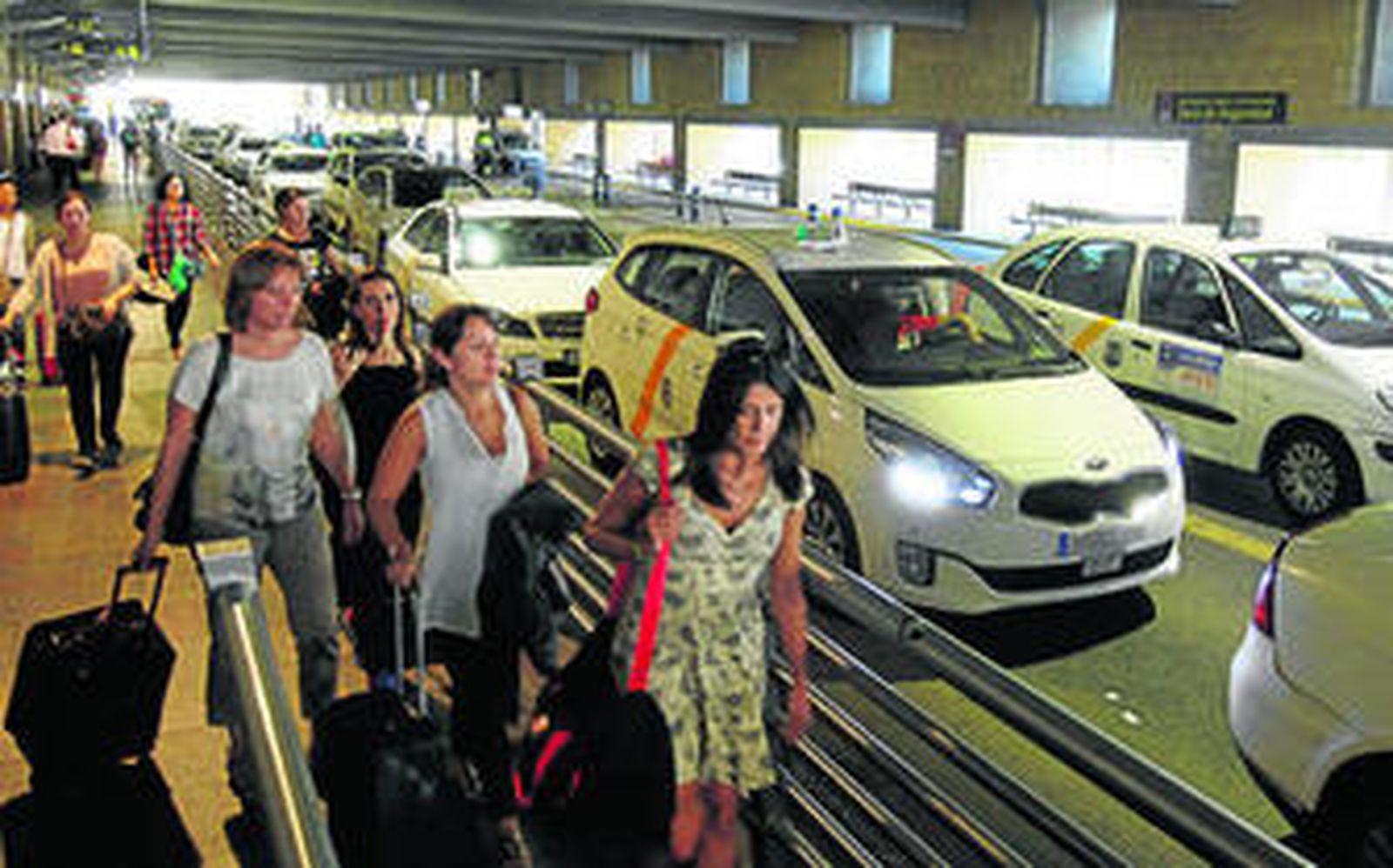 Un grupo de personas llega a la parada de taxis del aeropuerto de San Pablo, a mediodía de ayer, sin que hubiera presencia policial.