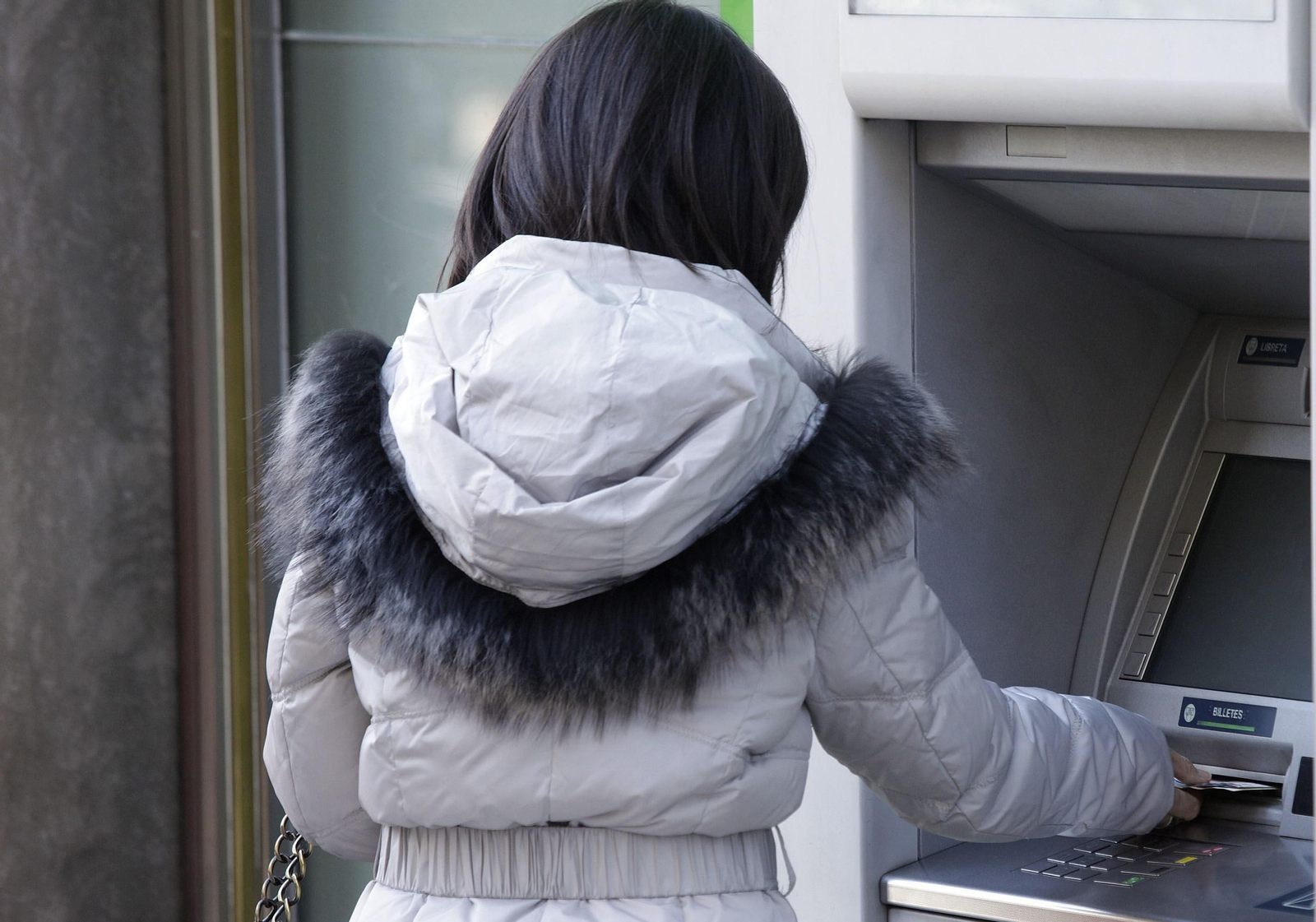 Una persona saca dinero de un cajero automático.