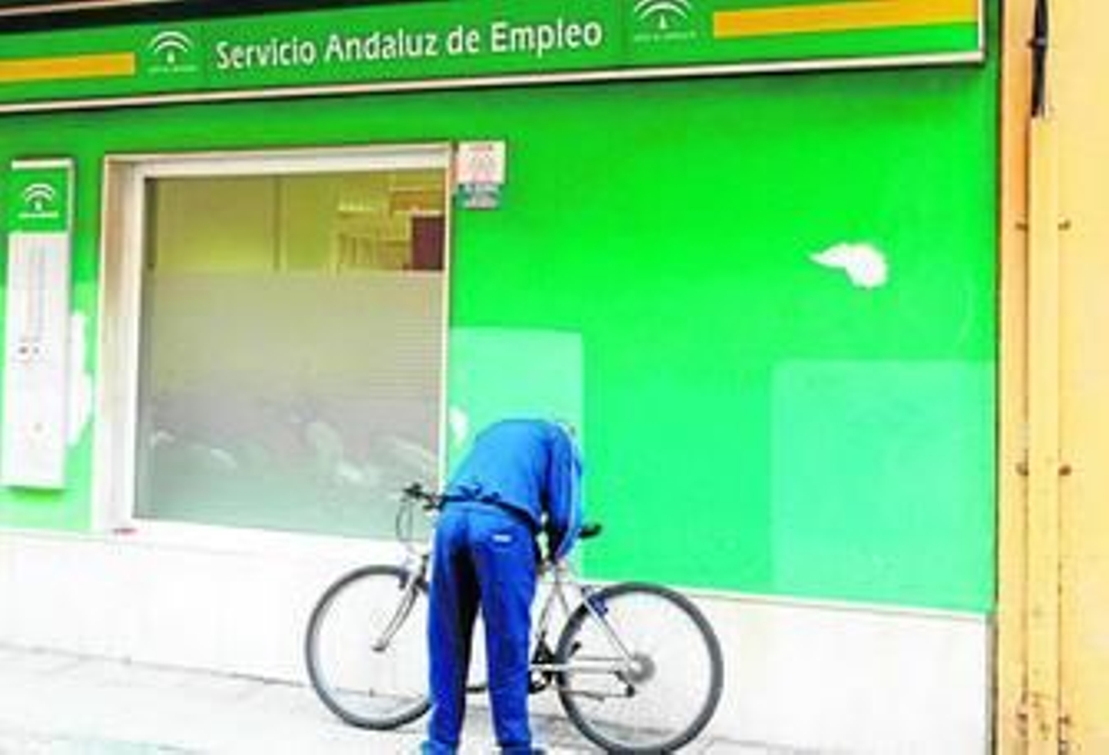 Una persona aparca su bicicleta en la fachada de la oficina del SAE en La Línea.
