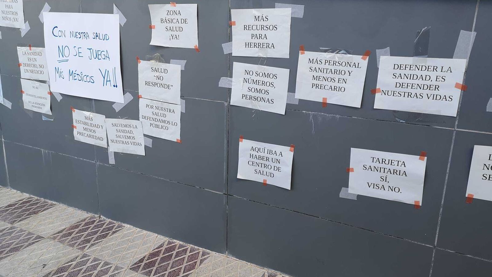 Carteles pegados en lo que los vecinos han llamado el muro de las reivindicaciones sanitarias.