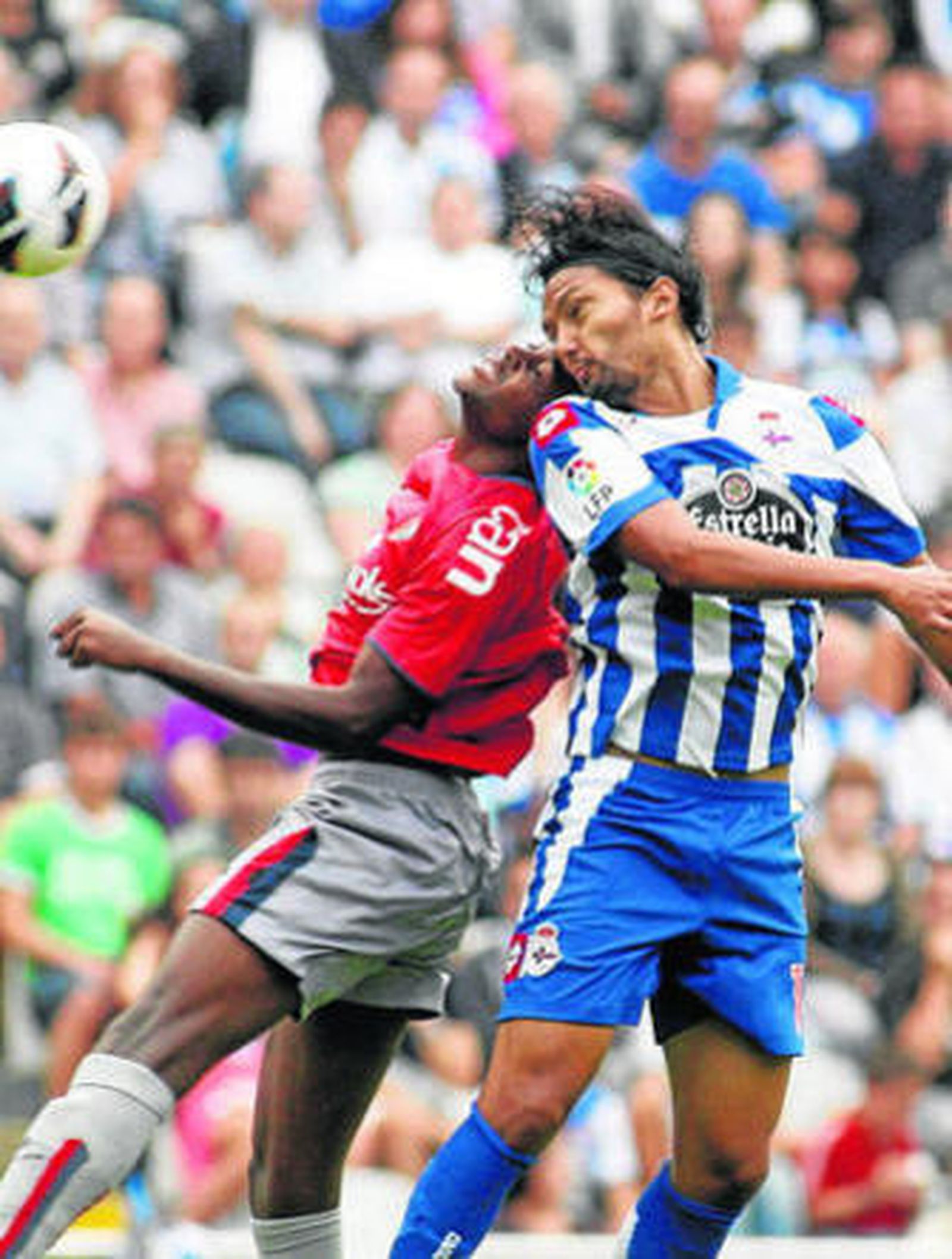 Abel Aguilar y Raoul Cedric saltan en la disputa de un balón.