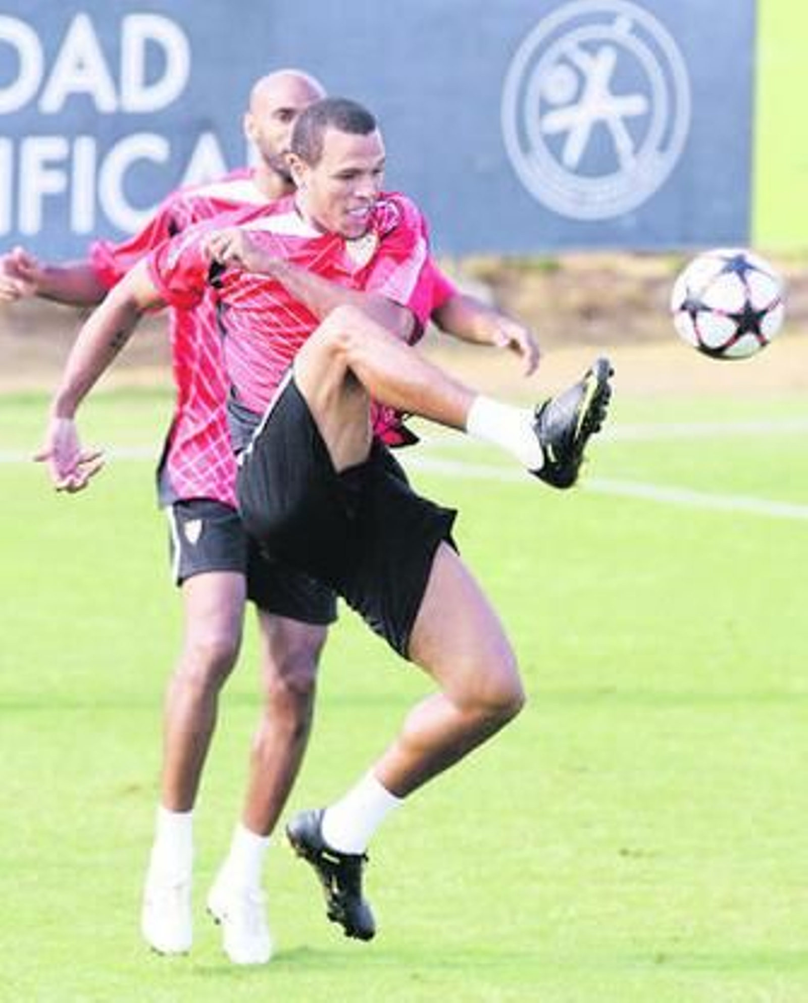 Luis Fabiano golpea el balón con cierta dificultad en el entrenamiento de ayer. Detrás, espera Kanoute.