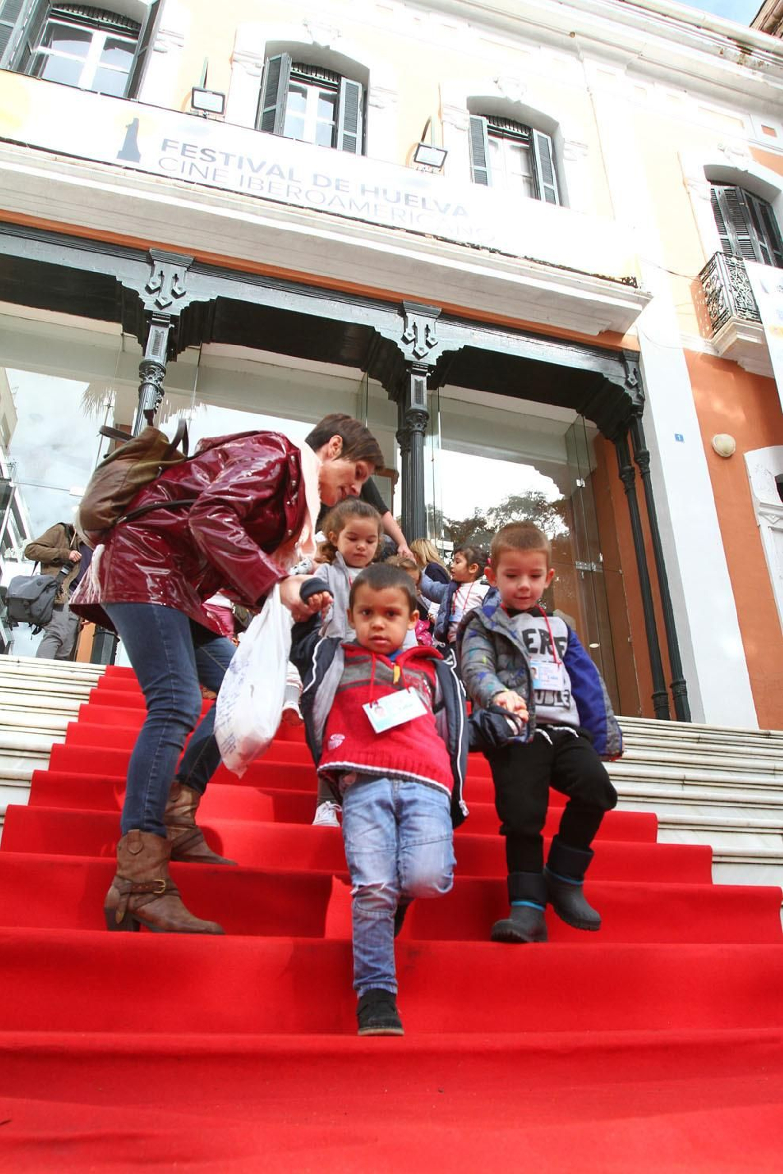 Un grupo de escolares baja por la alfombra roja de la Casa Colón.