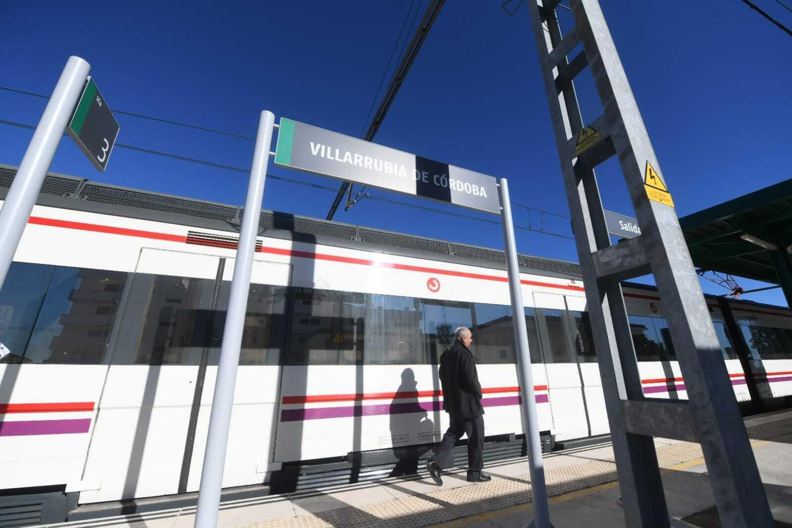 Un hombre pasa junto a un tren de Media Distancia en Villarrubia.
