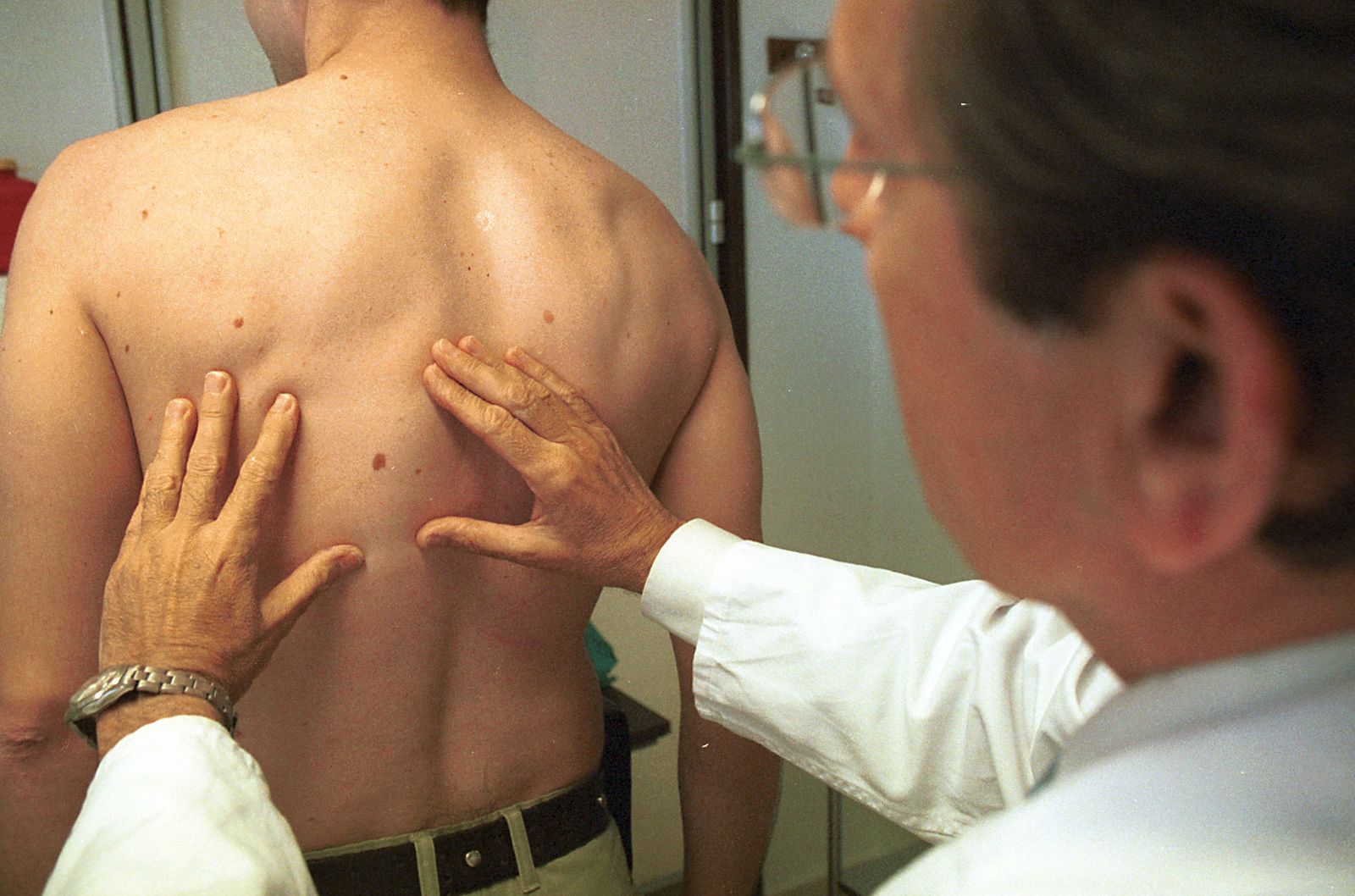 Exploración dermatológica en una consulta médica.