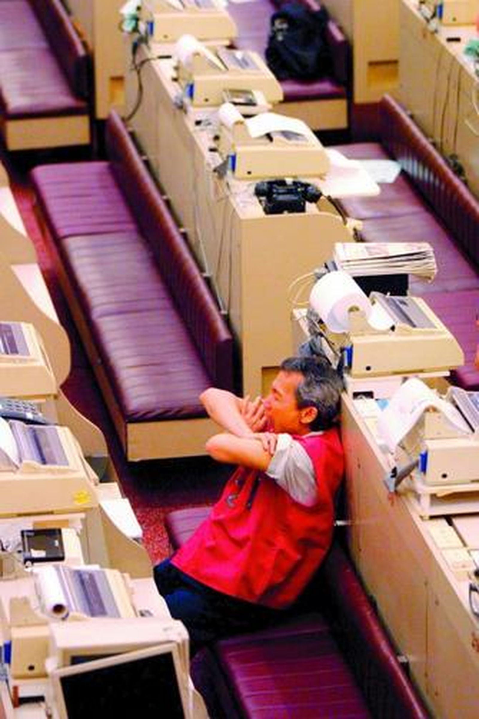Un trabajador chino bosteza en su puesto de trabajo.