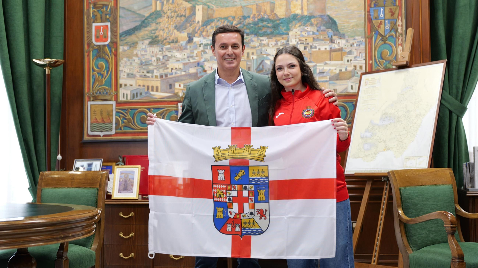 Carla Caballero posa junto Javier A. García con la bandera de la provincia de Almería.