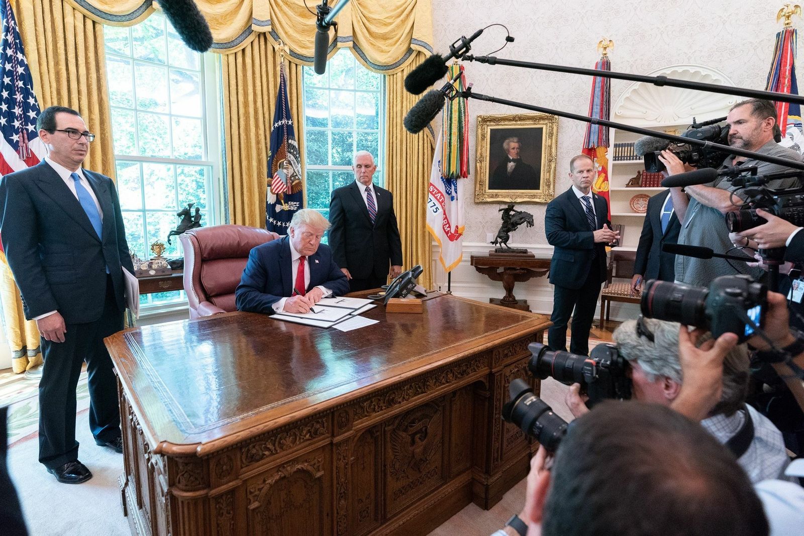 Trump, durante la firma el lunes de nuevas sanciones contra Irán, junto al secretario del Tesoro, Steve Mnuchin (izq.), y el vicepresidente, Mike Pence.