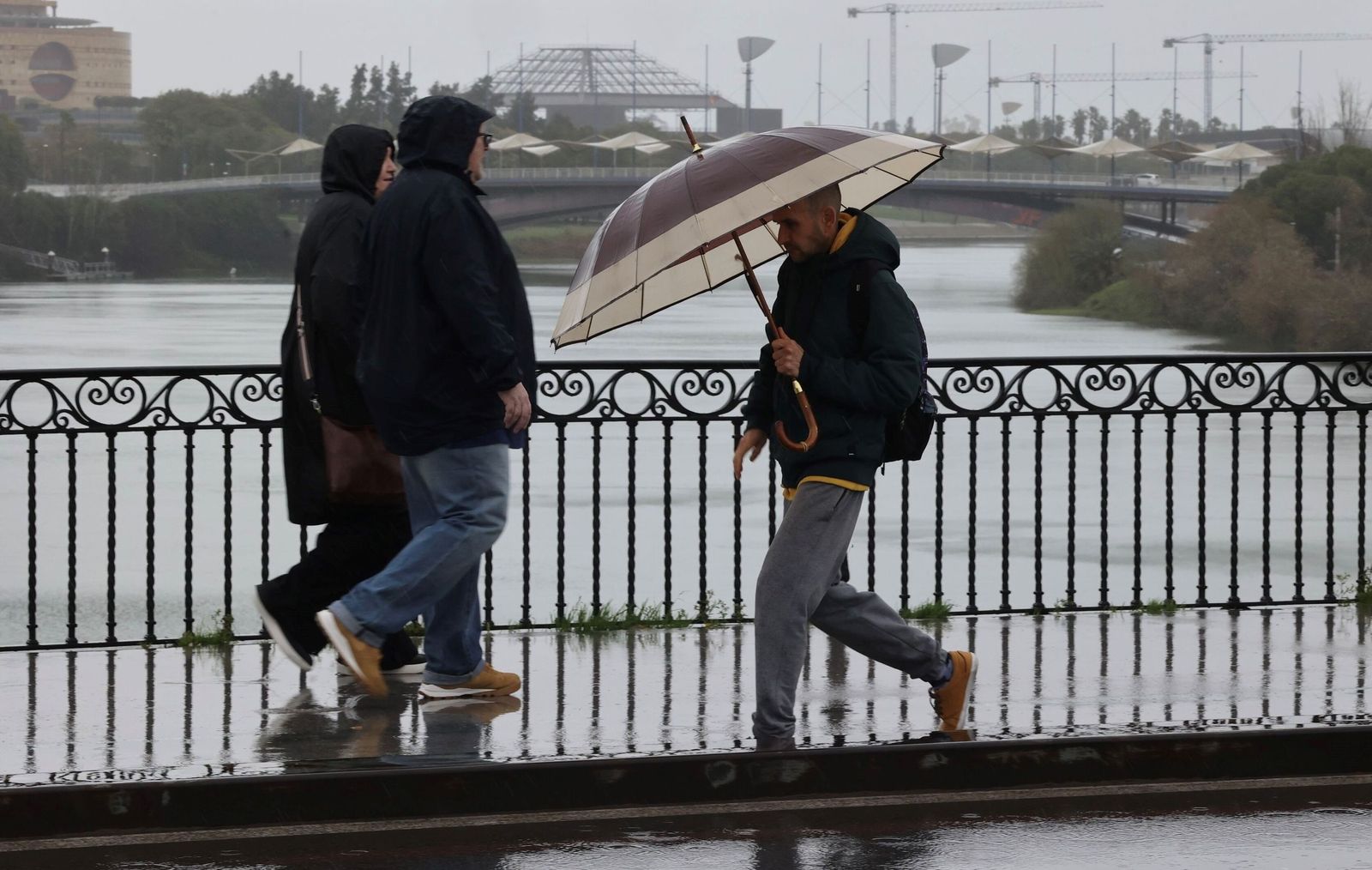 Paraguas y cielos grises, la estampa de una jornada en alerta por temporal en Sevilla
