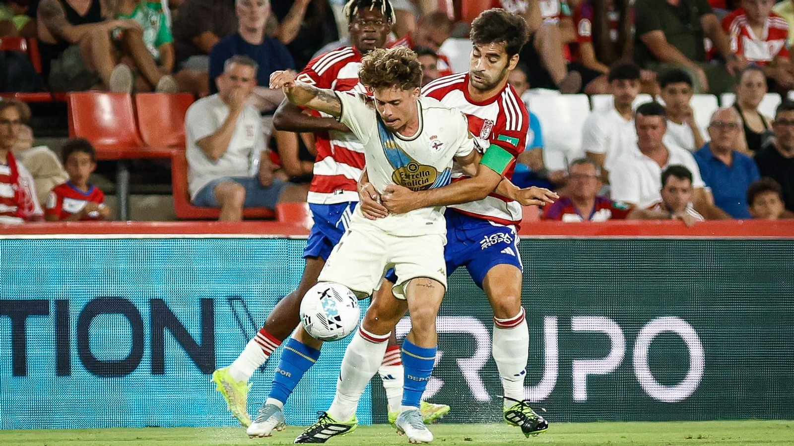 Mario Soriano, jugador del Deportivo de La Coruña, protege el balón ante Manu Trigueros (Granada CF).