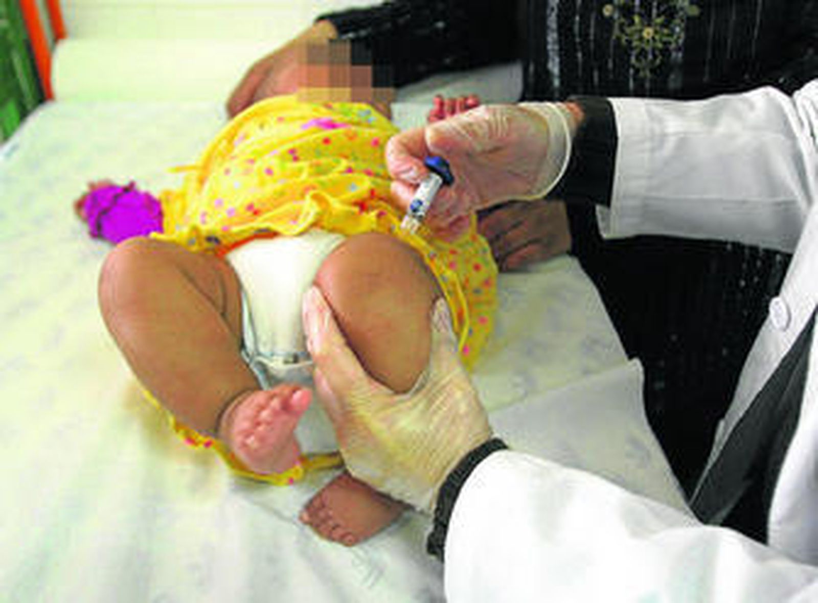 Un profesional sanitario vacuna a un bebé.