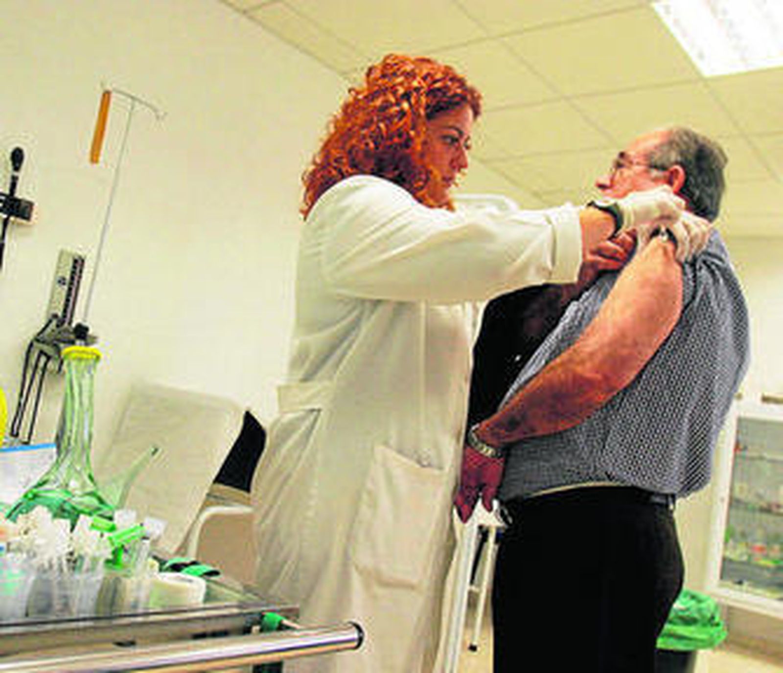 Una enfermera vacuna a un hombre contra la gripe.