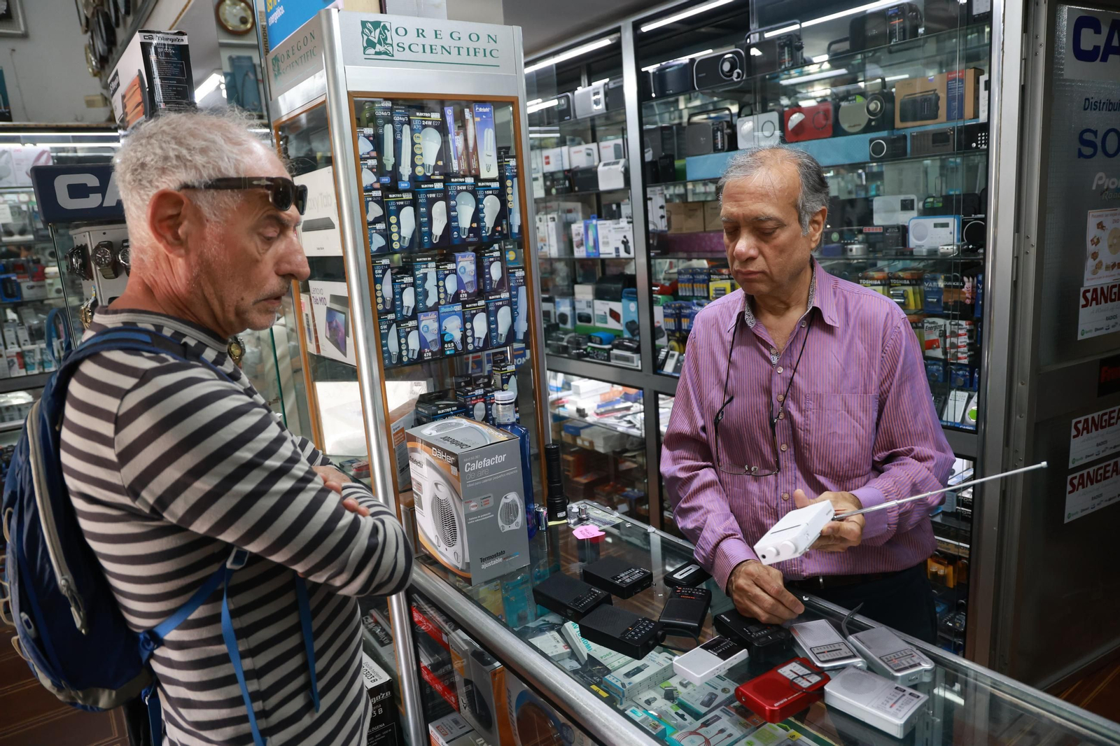 Uno de los regentes le muestra una radio a un cliente