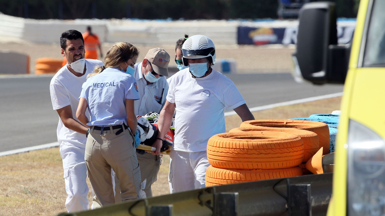 Los comisarios se llevan a Filippo Farioli tras sufrir una caída a la salida de la curva Dani Pedrosa.