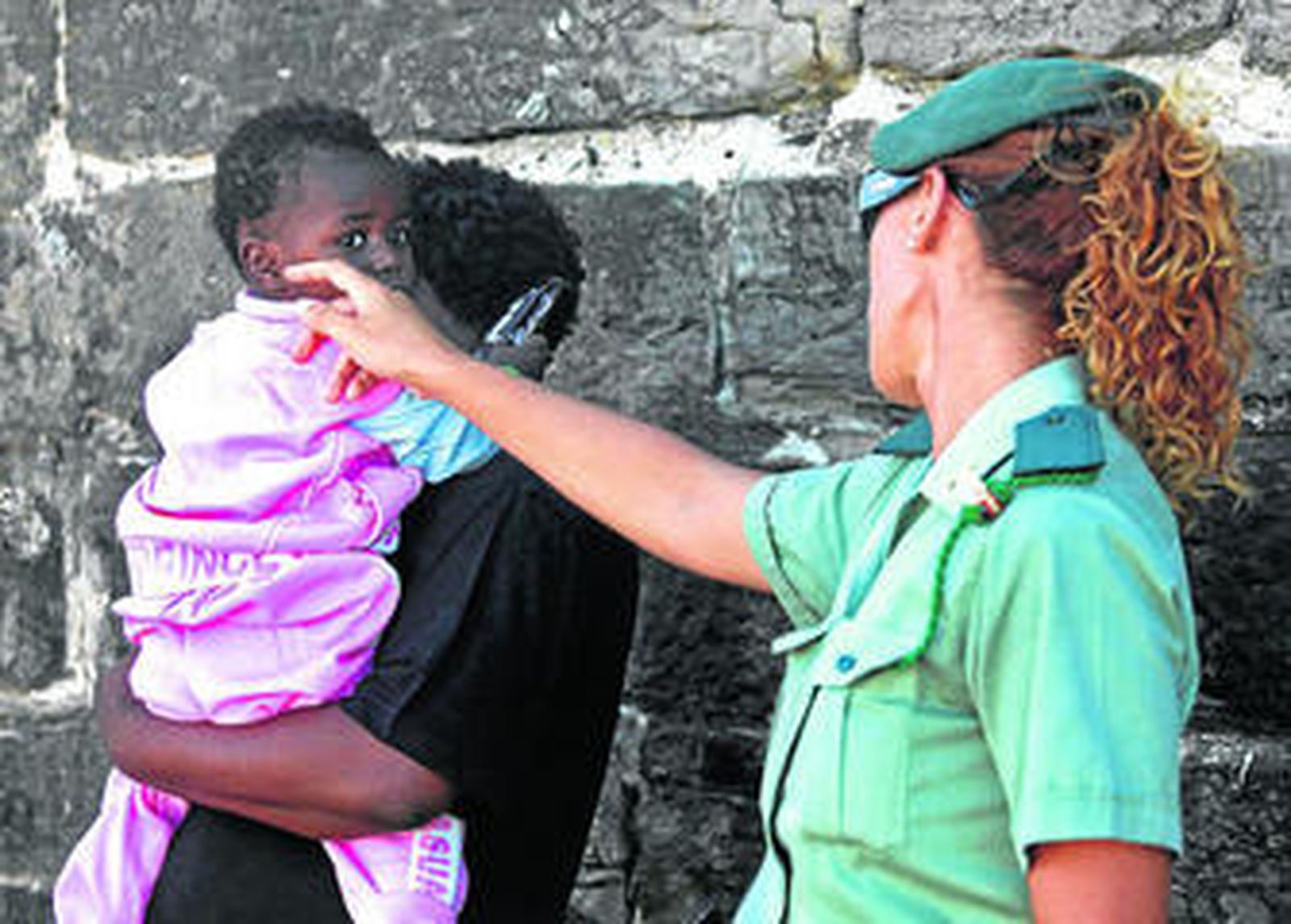Una guardia civil se interesa por un niño que llegó con su madre a Tarifa a bordo de una patera.
