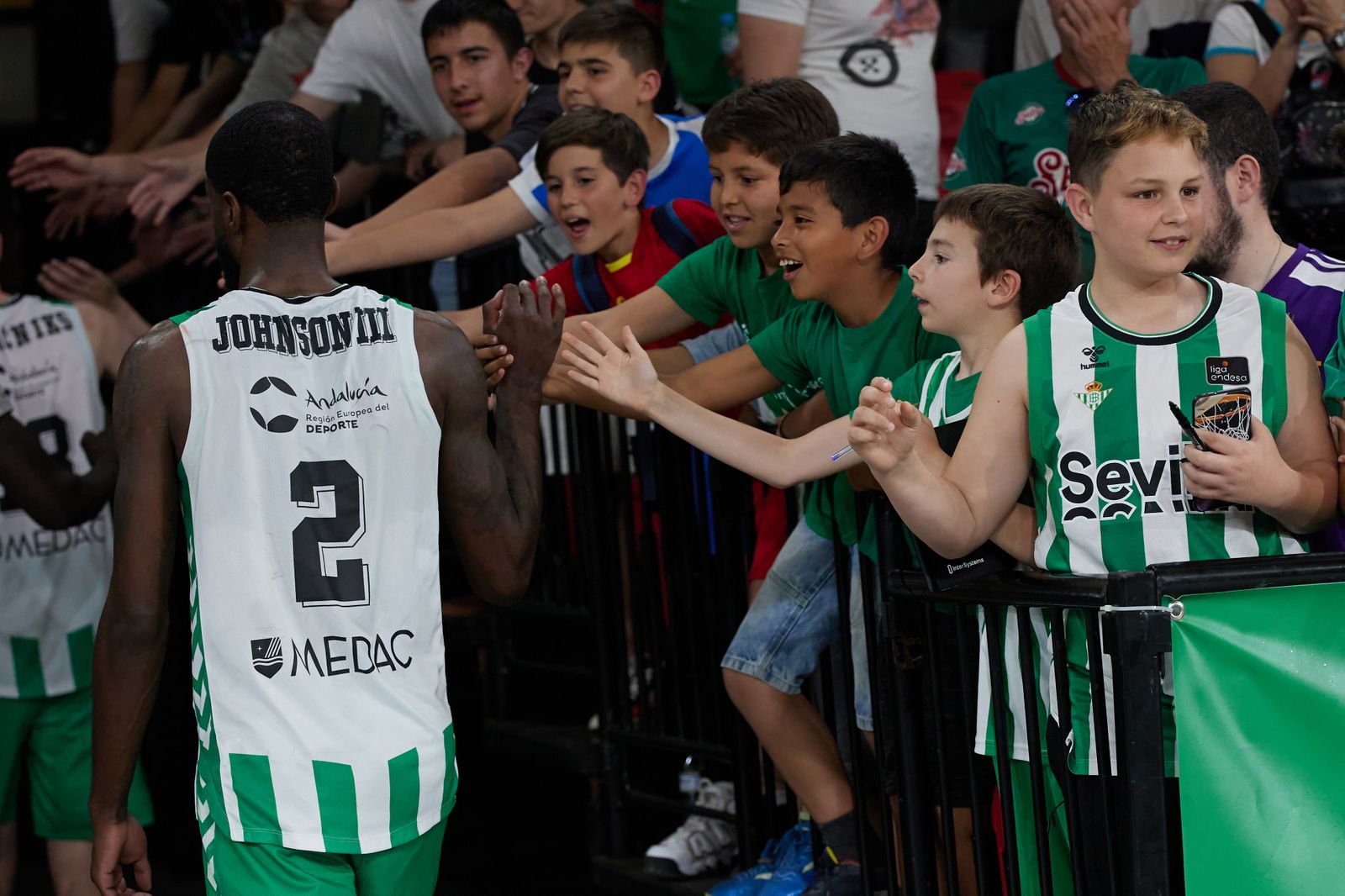 BJ Johnson saluda a jóvenes aficionados del Betis tras el triunfo en San Pablo contra el Fuenlabrada.