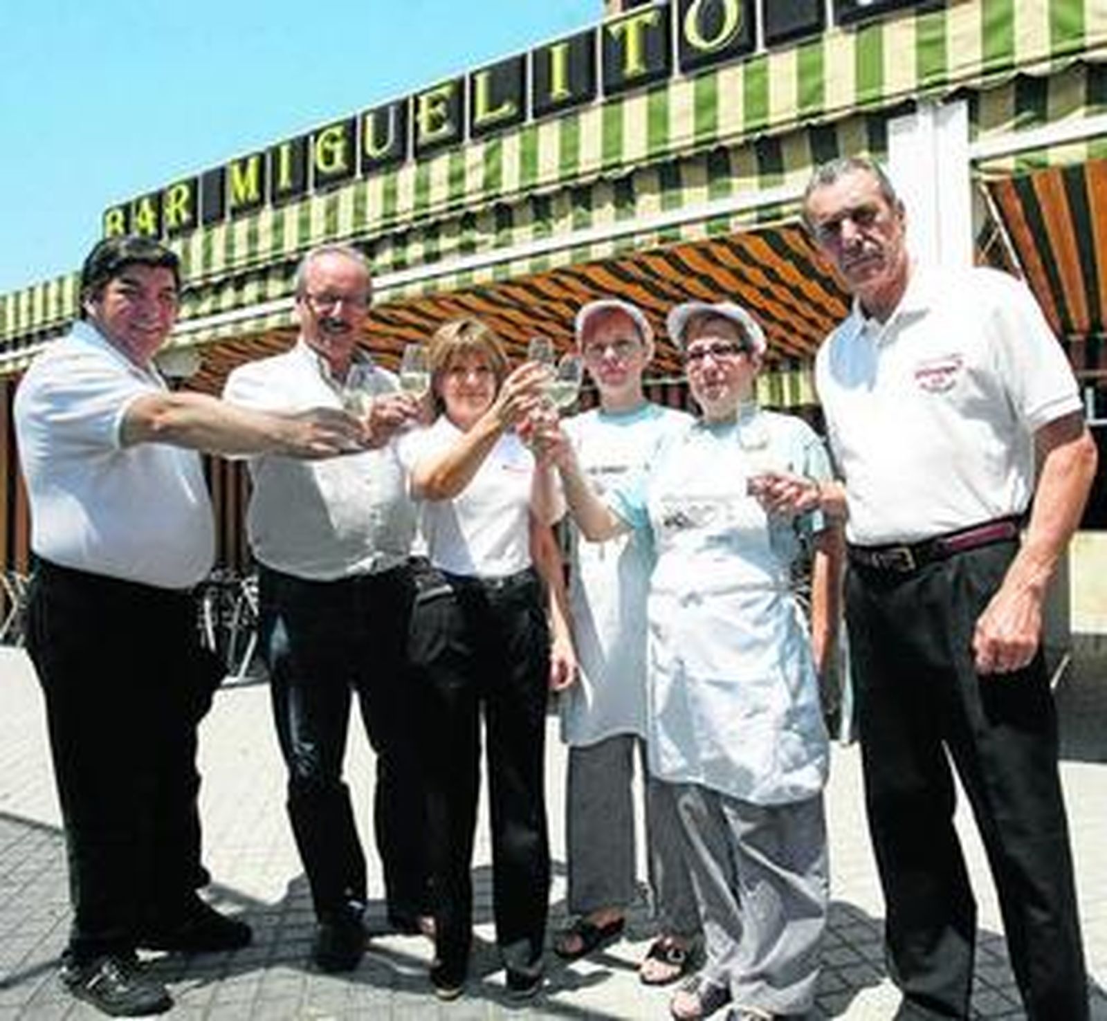 El personal del bar Miguelito hace un brindis para festejar la larga vida del negocio.