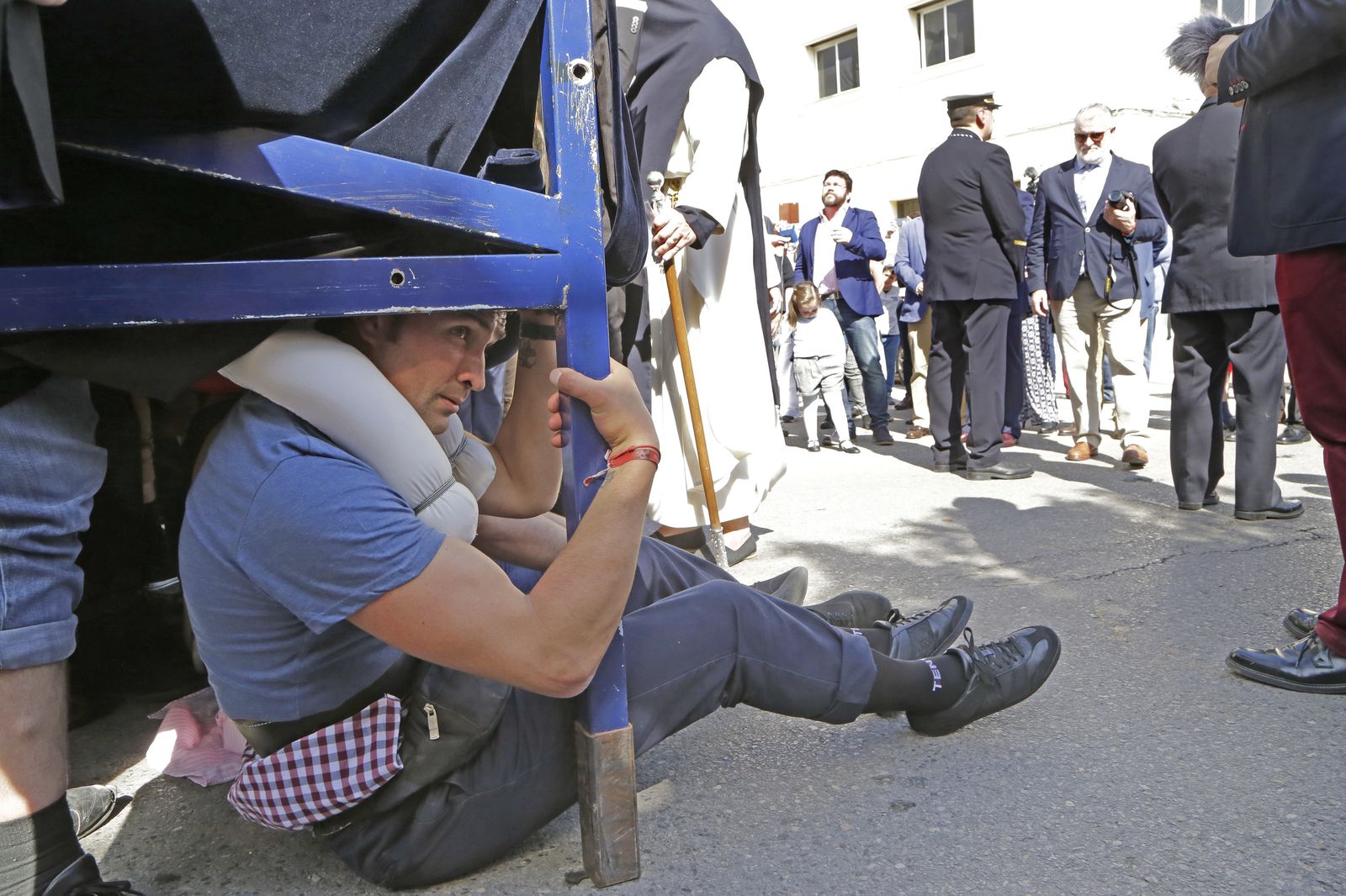Un costalero aprovecha el descanso para tomar aire en el paso de la Virgen del Consuelo en el barrio del Pelirón.