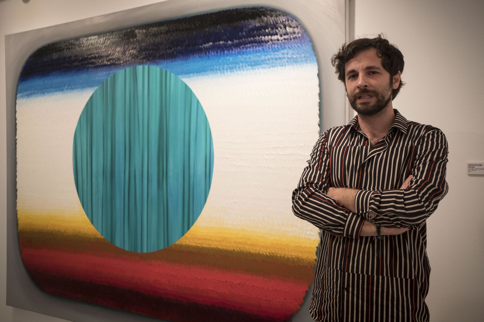 Alejandro Botubol, junto a una de sus obras en la Sala Rivadavia.