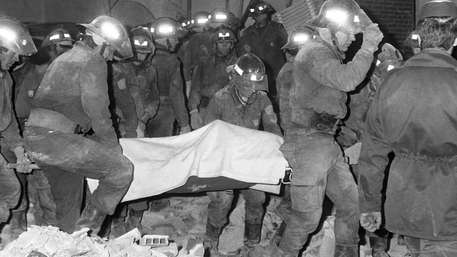 Los bomberos se llevan uno de los cadáveres de las víctimas del atentado en El Descanso.