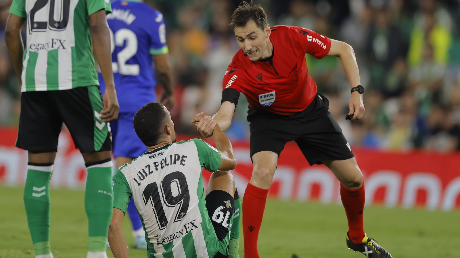 El colegiado del partido contra el Getafe, Ricardo de Burgos Bengoetxea ayuda a Luiz Felipe a levantarse.