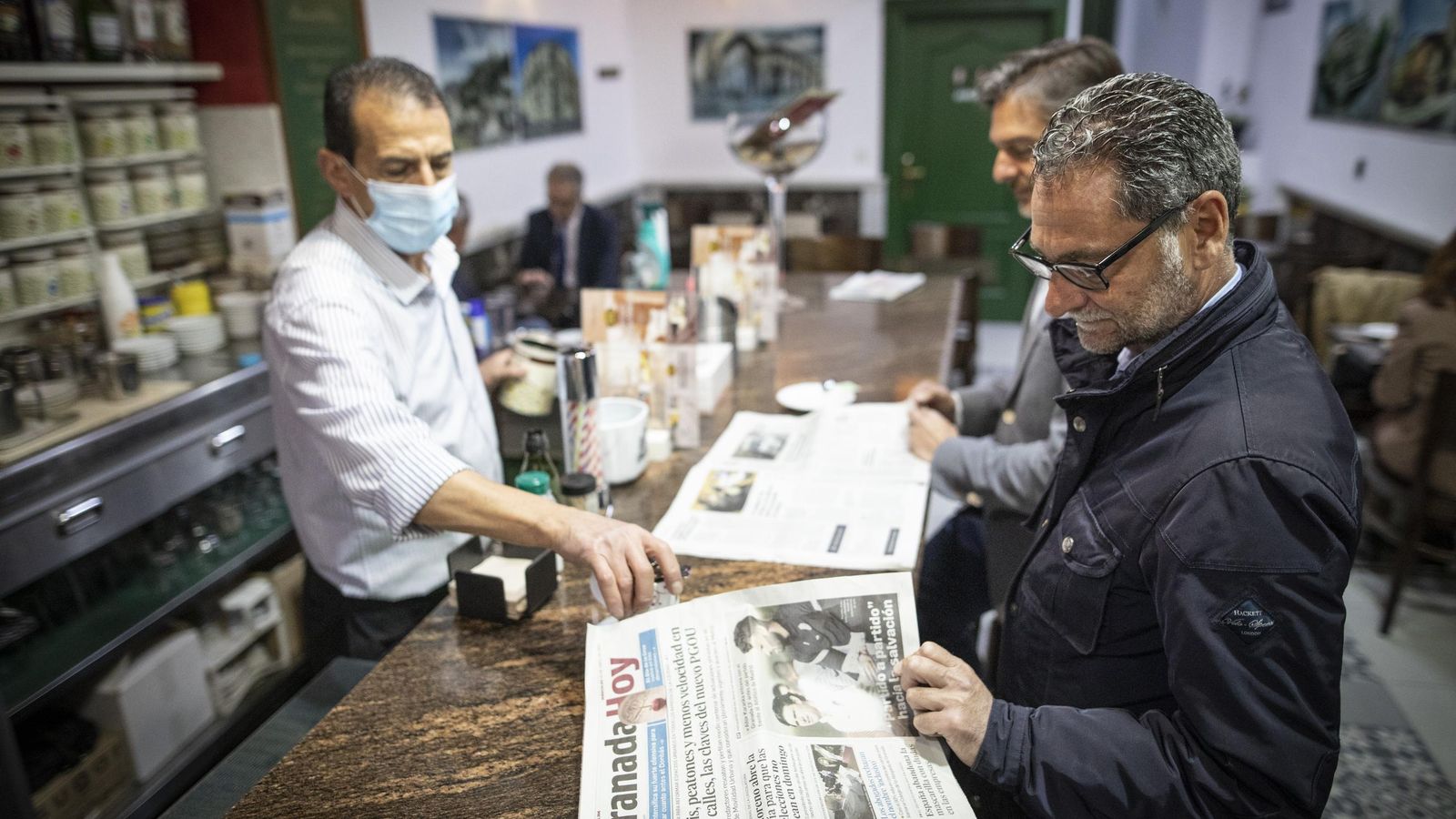 Un camarero sirve un café con la mascarilla puesta