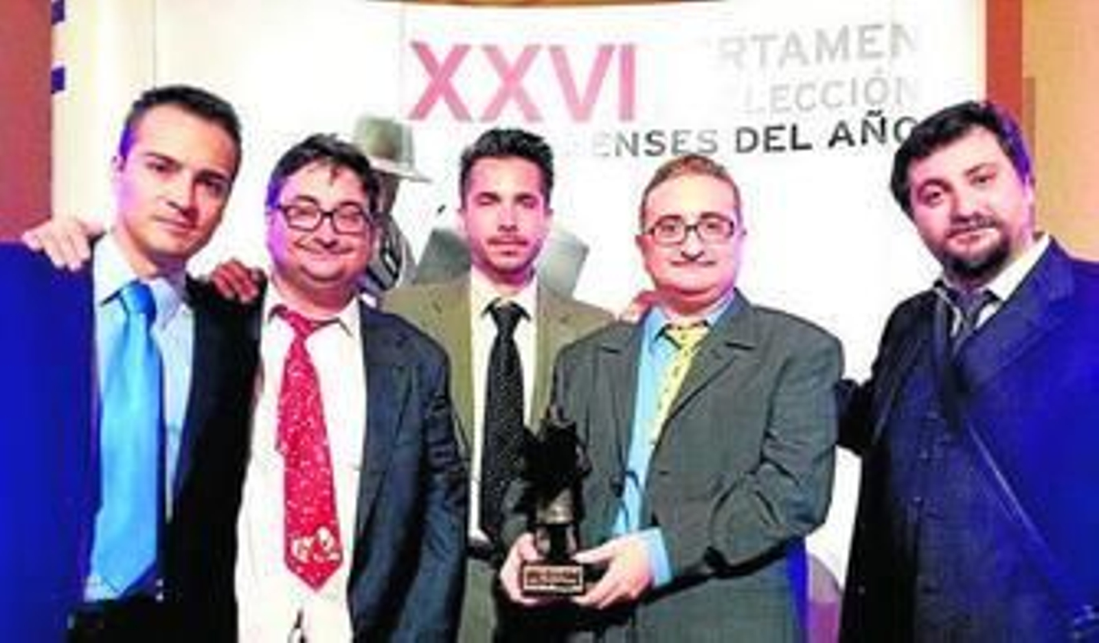 Marco Macías sostiene el Onubense del Año otorgado por los lectores de 'Huelva Información' en 2014, junto a sus hermanos y otros miembros de la Asociación Cultural Seis Viñetas.