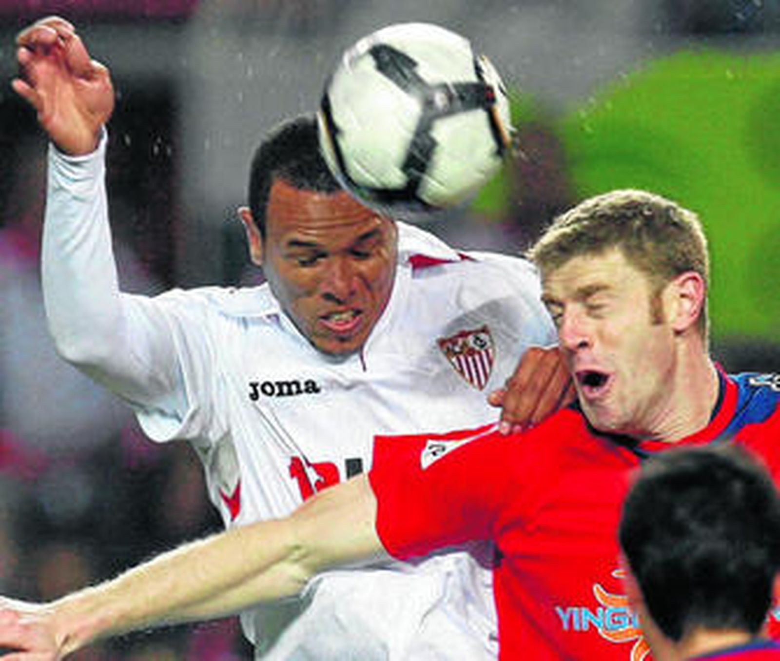 El brasileño Luis Fabiano supera en el salto al osasunista Sergio para cabecear el balón.